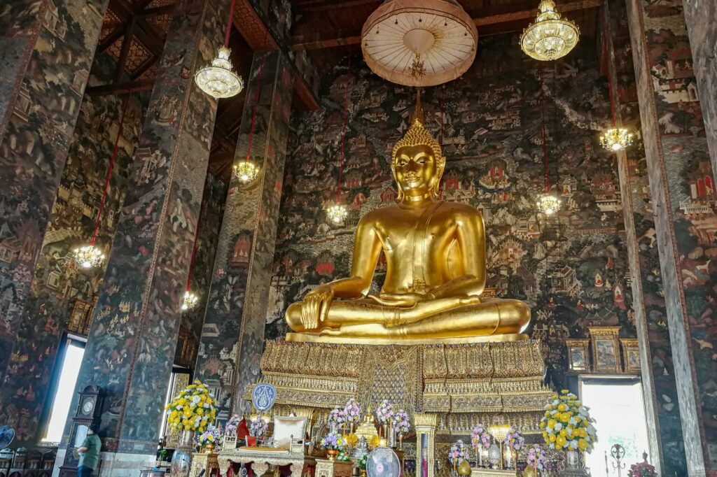 Wat Suthat, Bangkok, Tajlandia
Wielki złoty posąg Buddy w pozycji medytacyjnej w świątyni Wat Suthat w Bangkoku, otoczony bogato zdobionym ołtarzem i kwiatami