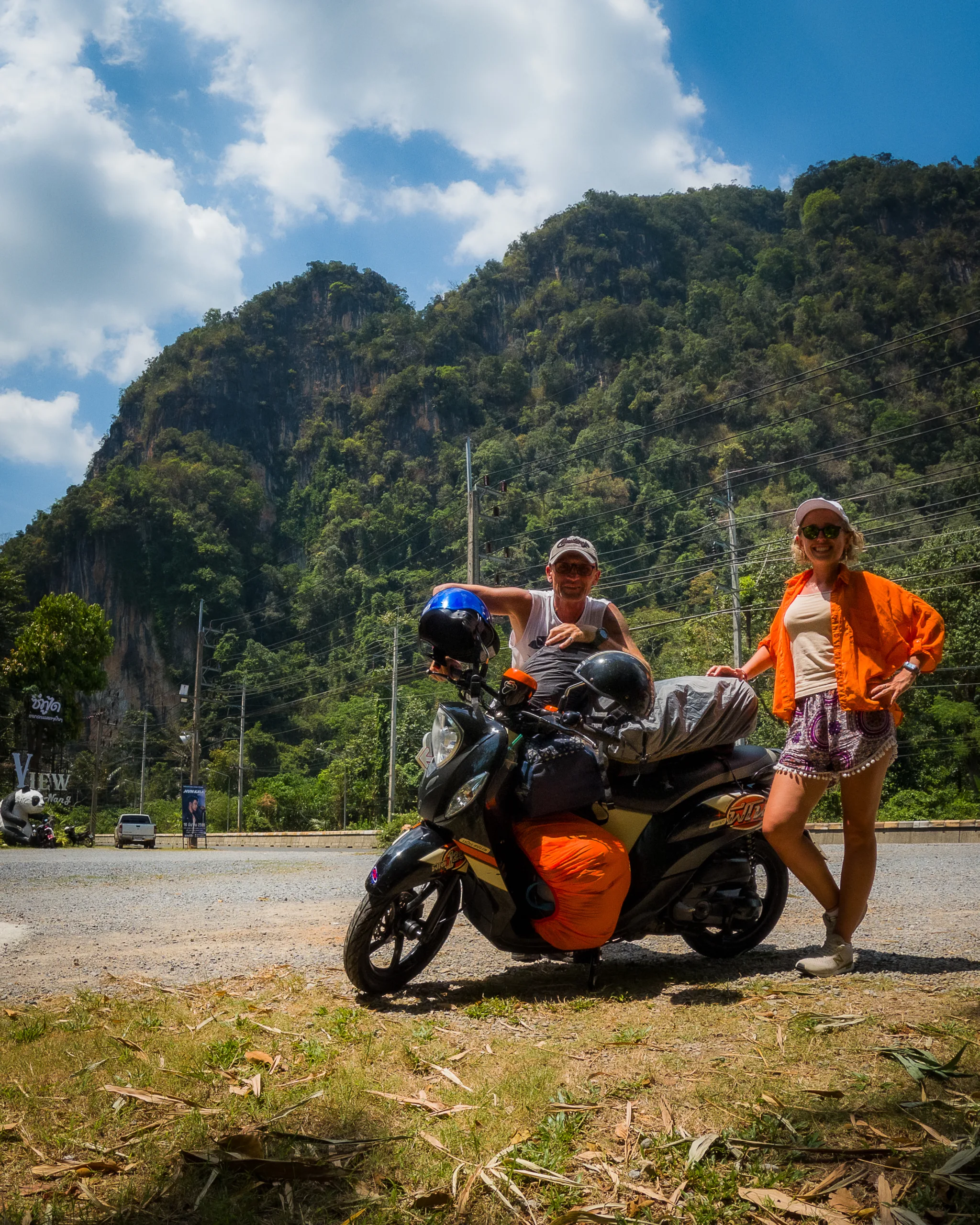 Podróżnicy przy skuterze z bagażami, w tle zielone góry i błękitne niebo Krabi informacje praktyczne