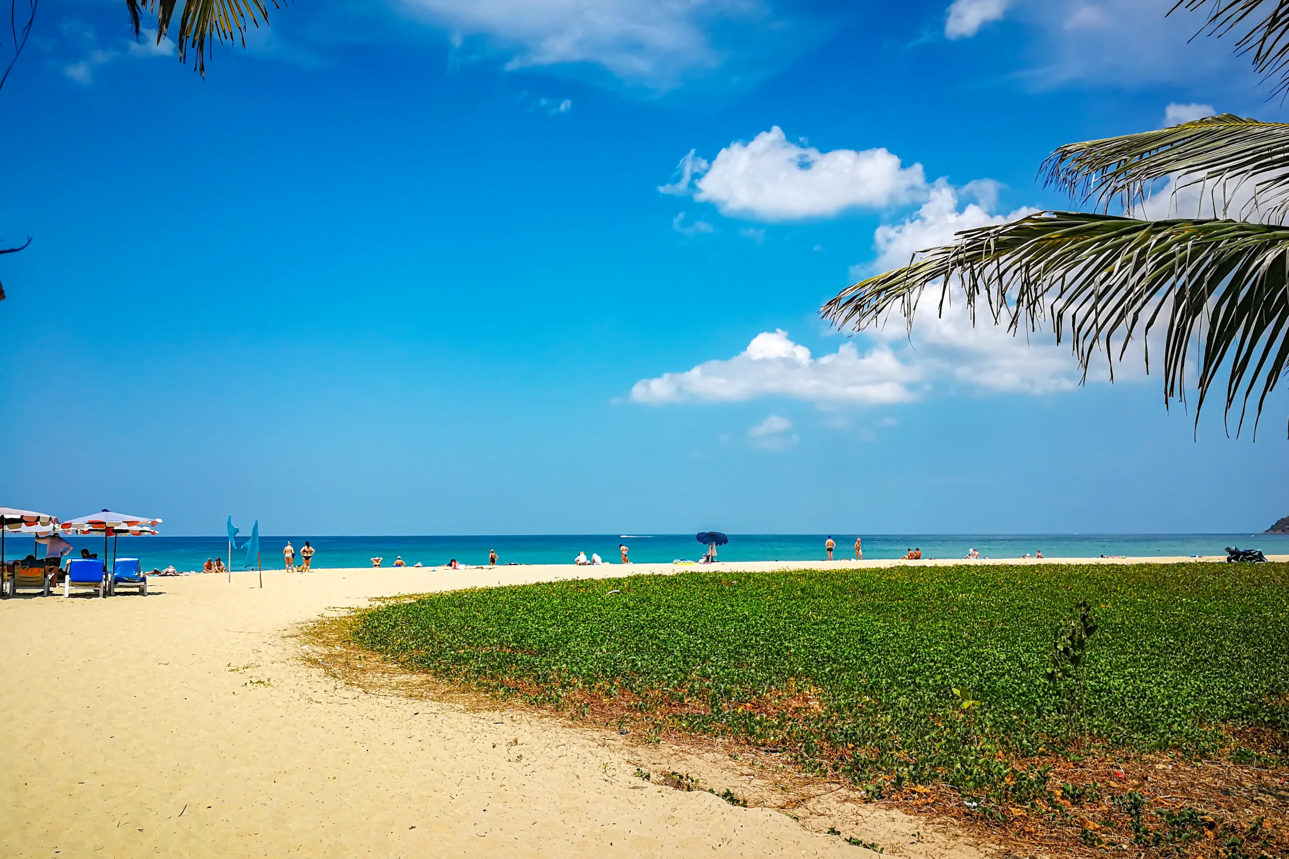 Słoneczna plaża w Phuket z białym piaskiem, turkusowym morzem i błękitnym niebem