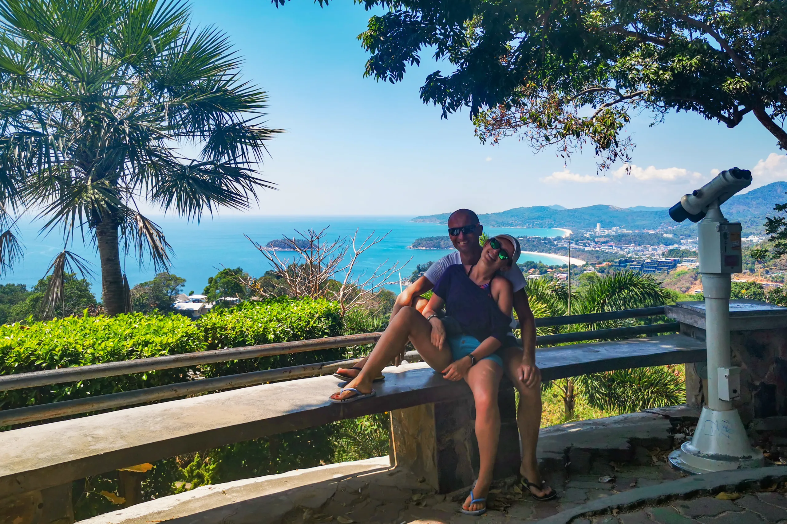 Para podróżników siedząca na ławce z widokiem na turkusowe morze, plażę i miasto - Phuket Tajlandia