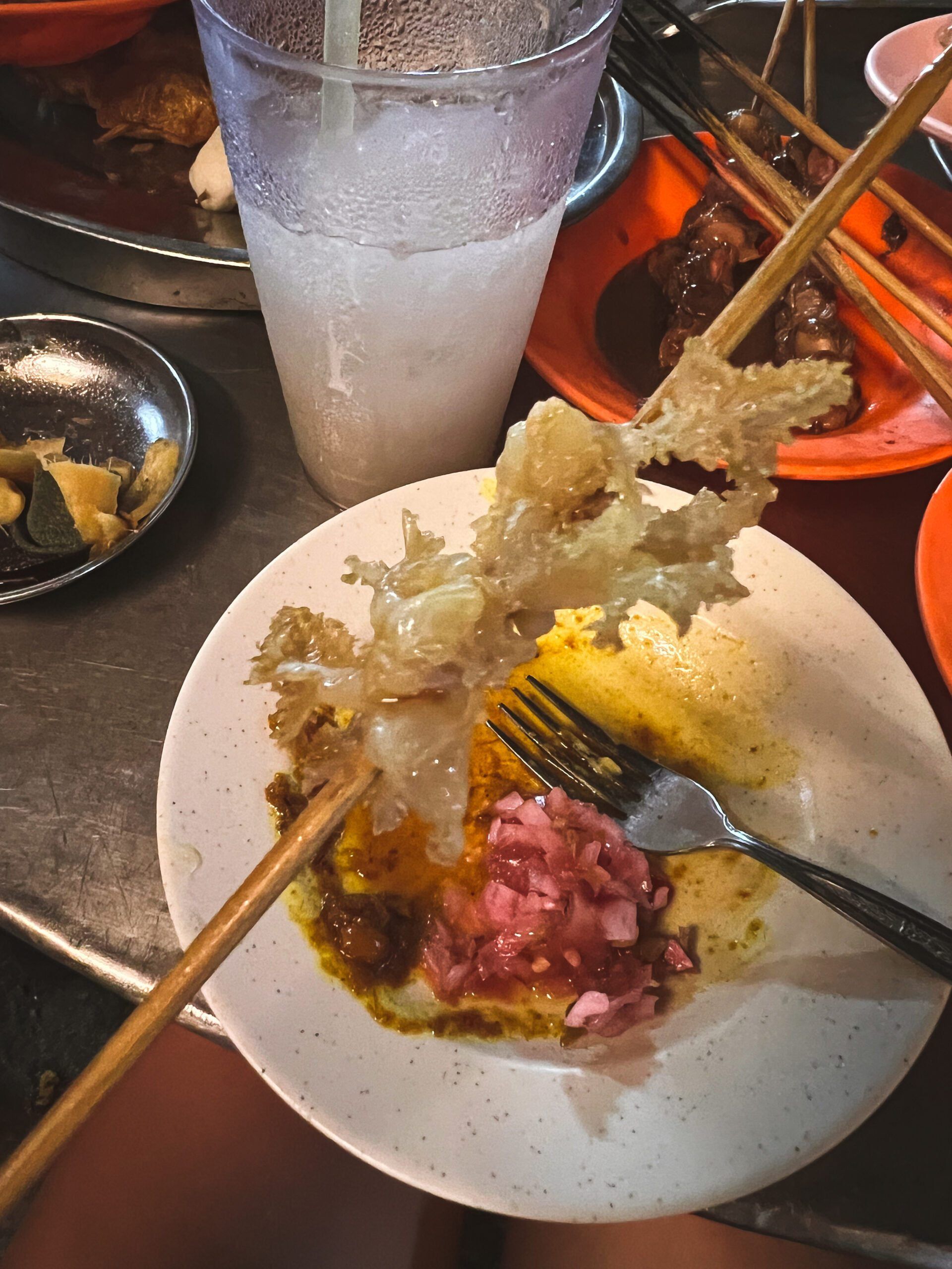 Meduza podana na patyku w stylu malezyjskiego Lok Lok, serwowana z sosem curry i marynowaną cebulą