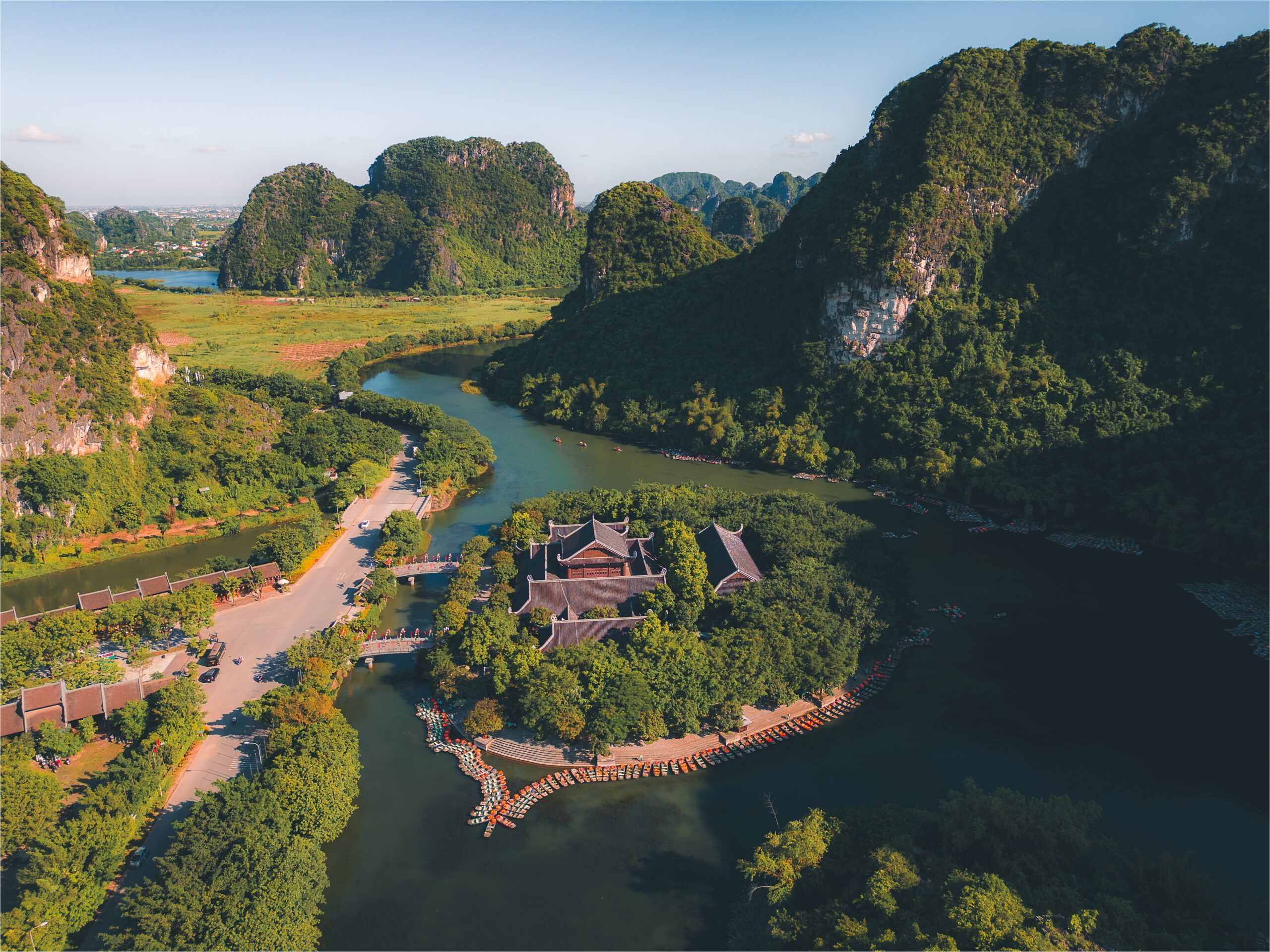 Widok z lotu ptaka na kompleks świątynny otoczony rzeką i górami wapiennymi w Trang An, Wietnam