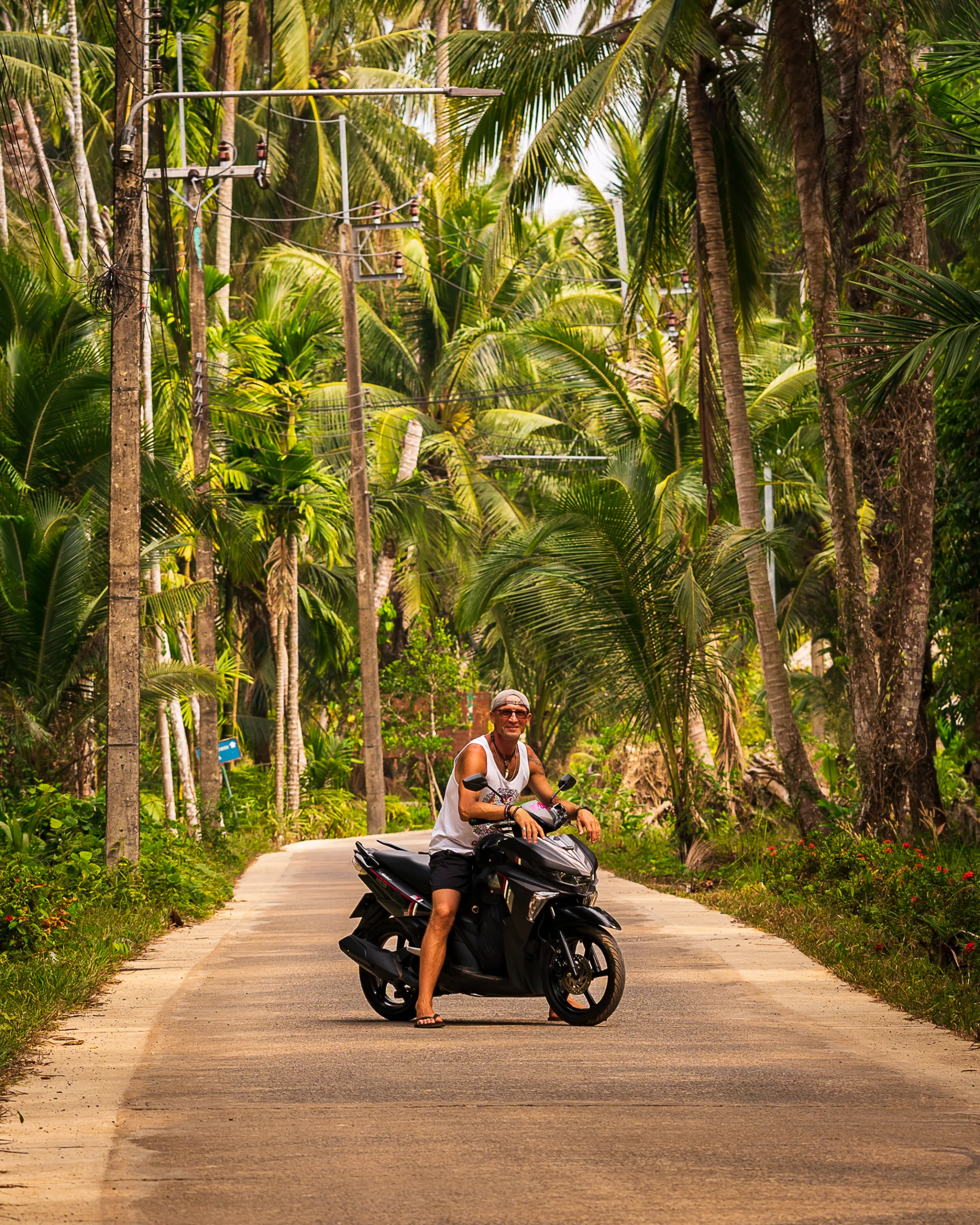Jazda skuterem po wyspie Koh Chang – podróżnik na tle palmowego krajobrazu w Tajlandii