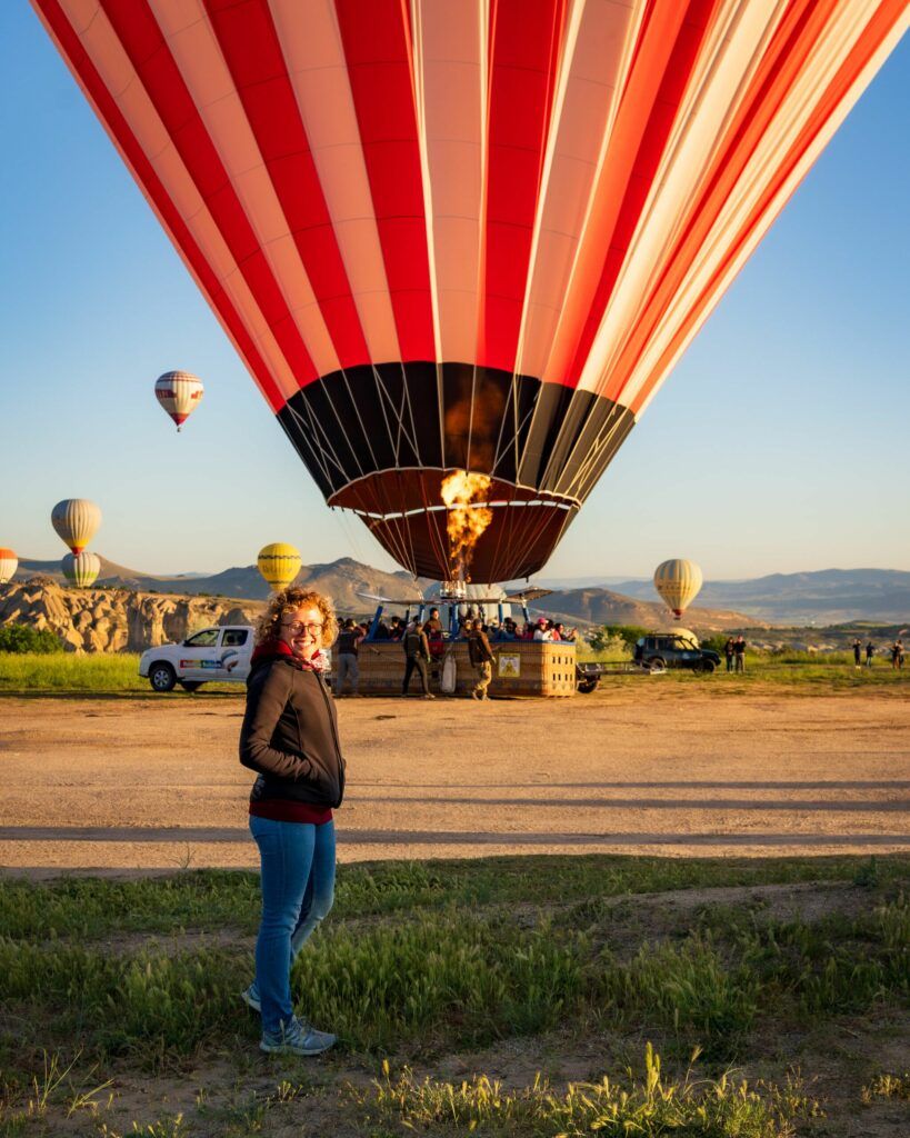 Balony na ogrzane powietrze w Kapadocji nad czerwoną doliną o wschodzie słońca.