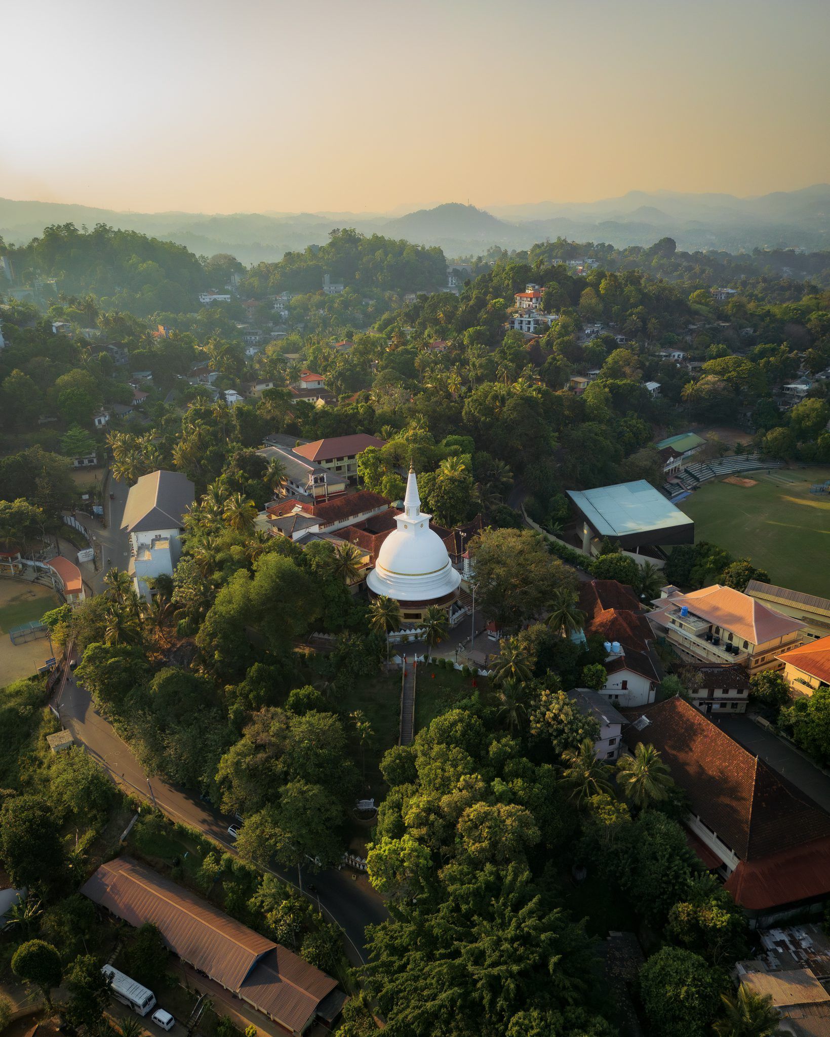 Kandy, Sri Lanka – widok z lotu ptaka na białą stupę buddyjską otoczoną zielenią i pagórkowatym krajobrazem.