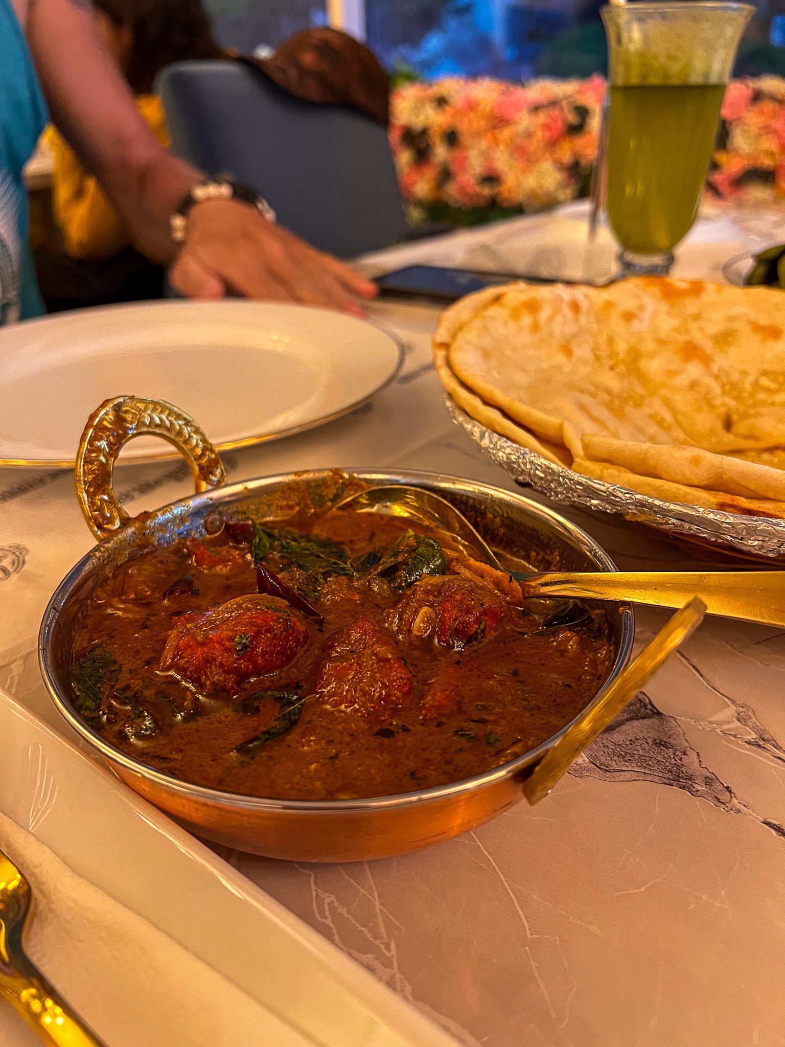 Tradycyjne lankijskie curry z przyprawami i chlebkiem naan, podane w miedzianym naczyniu.
