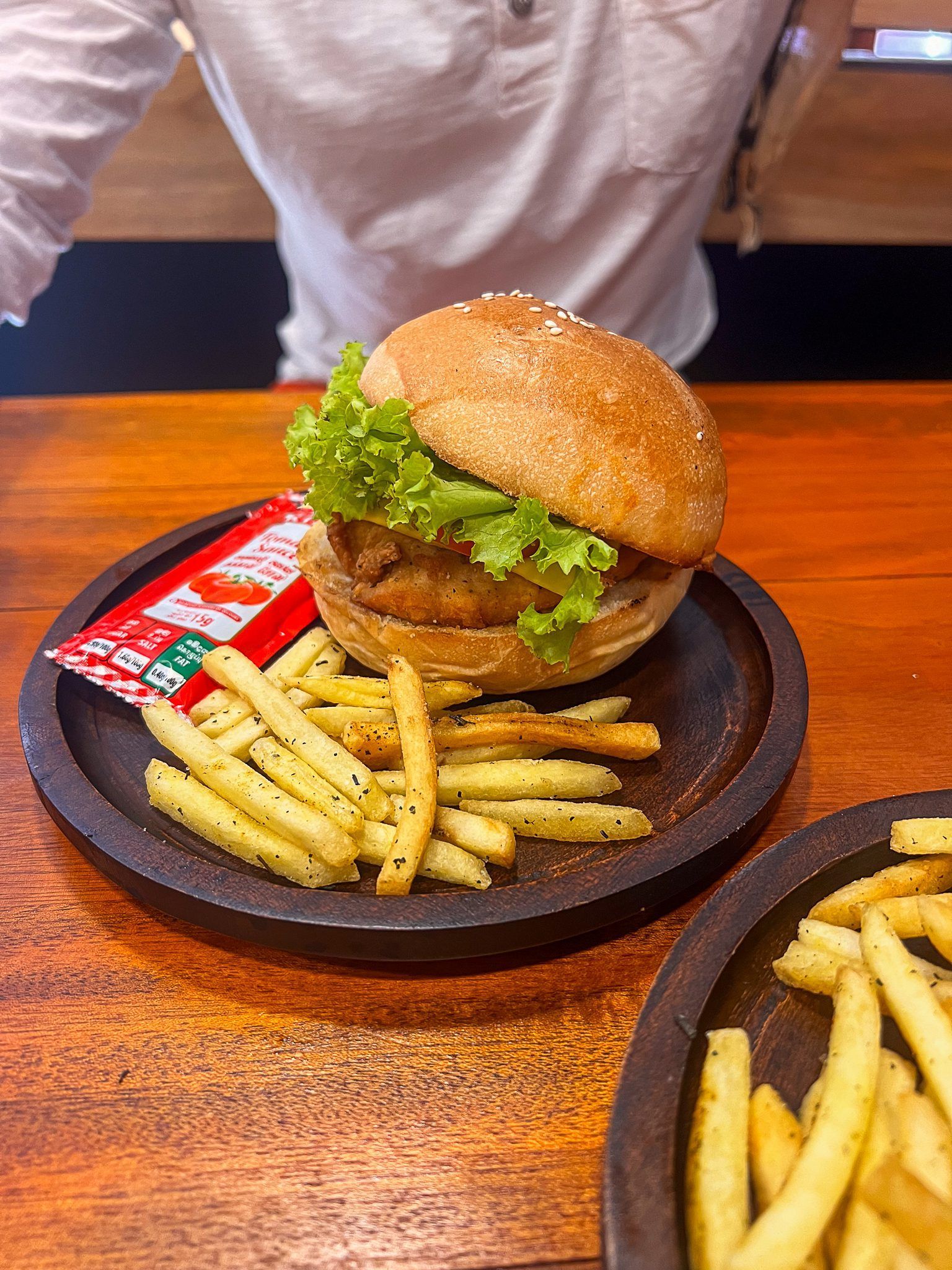 Burger z frytkami podany na drewnianym talerzu w restauracji na Sri Lance.