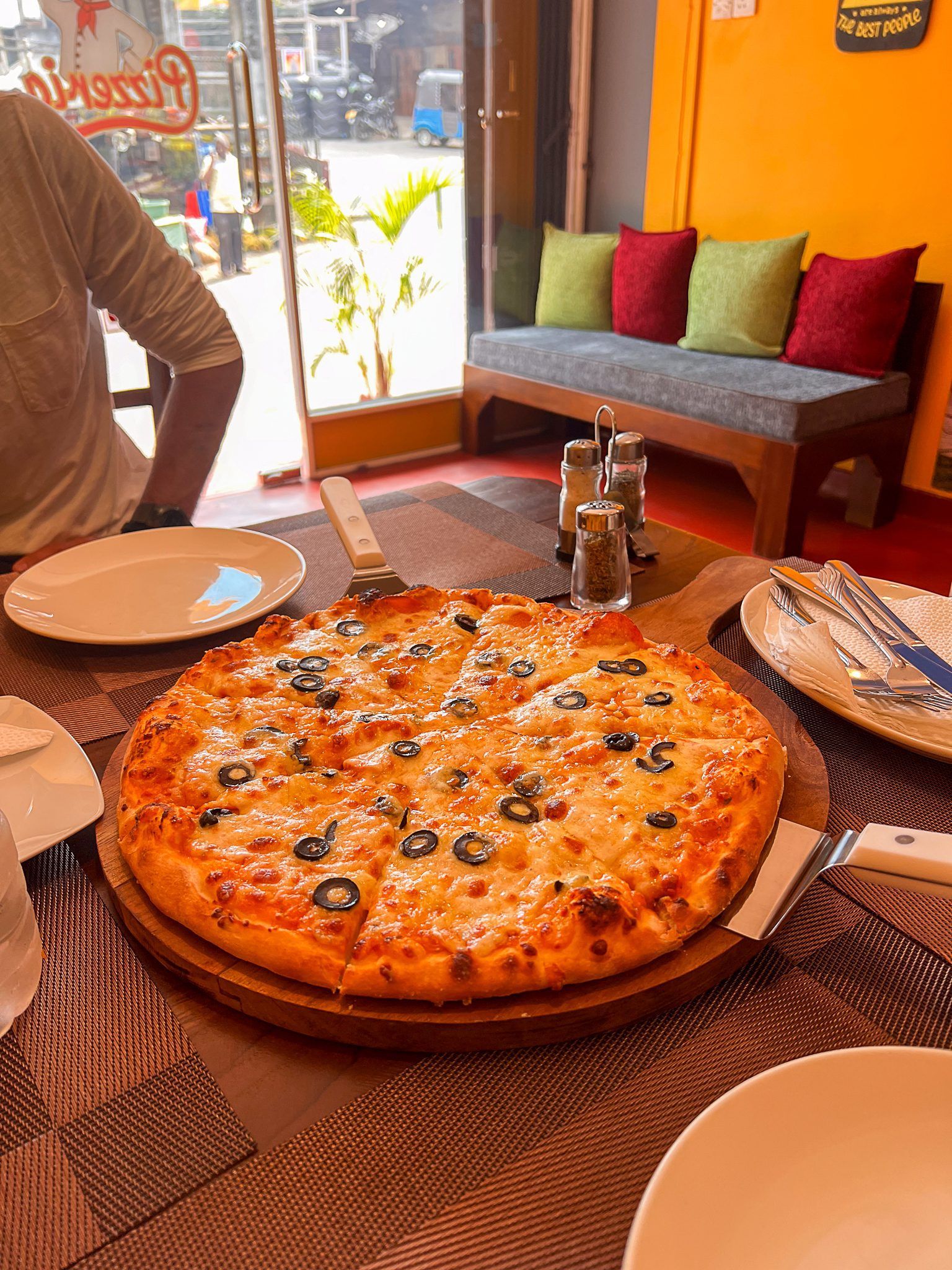 Pizza z czarnymi oliwkami podana na drewnianej desce w restauracji na Sri Lance.