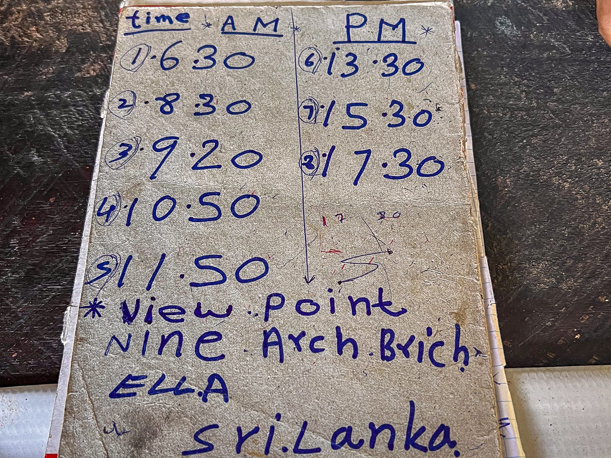 Rozkład jazdy pociągów widziany na kartce w Ella, Sri Lanka – godziny przejazdu przy punkcie widokowym na most Nine Arch Bridge.