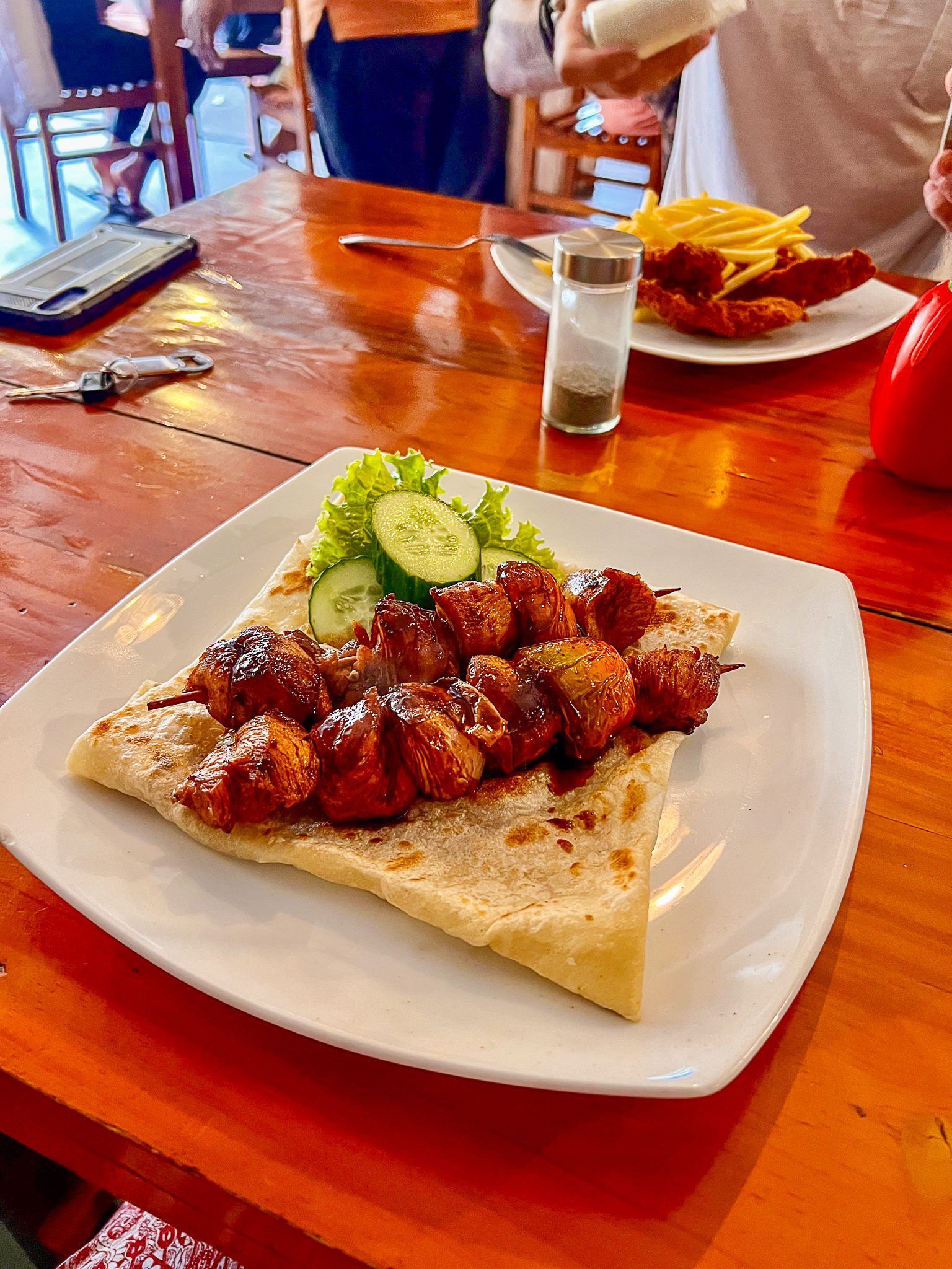 Grillowane szaszłyki z kurczaka podane na ciepłej tortilli z sałatą i ogórkiem w restauracji na Sri Lance.