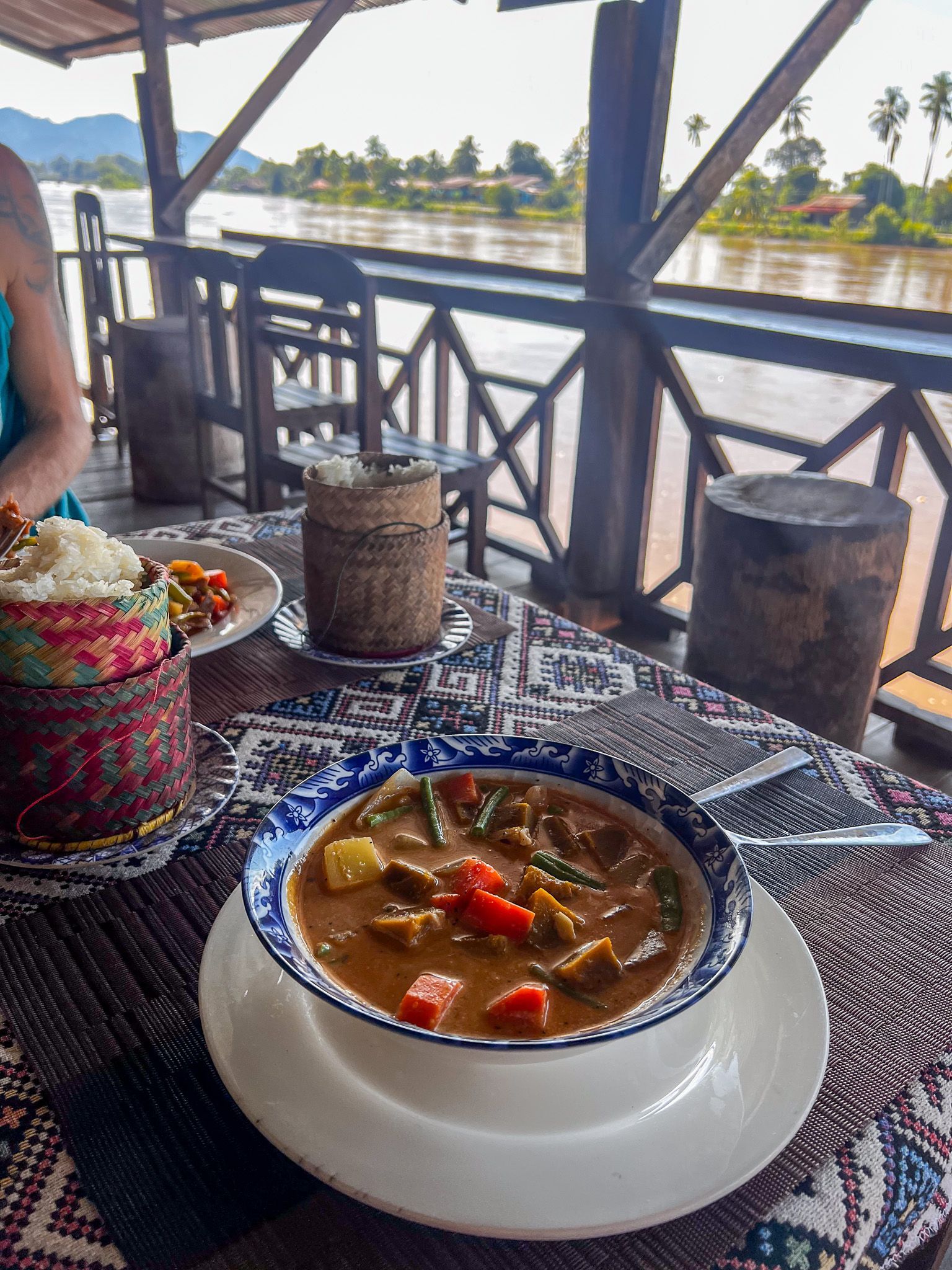 Tradycyjna laotańska zupa curry z warzywami i kleistym ryżem, podana w restauracji nad brzegiem Mekongu.
