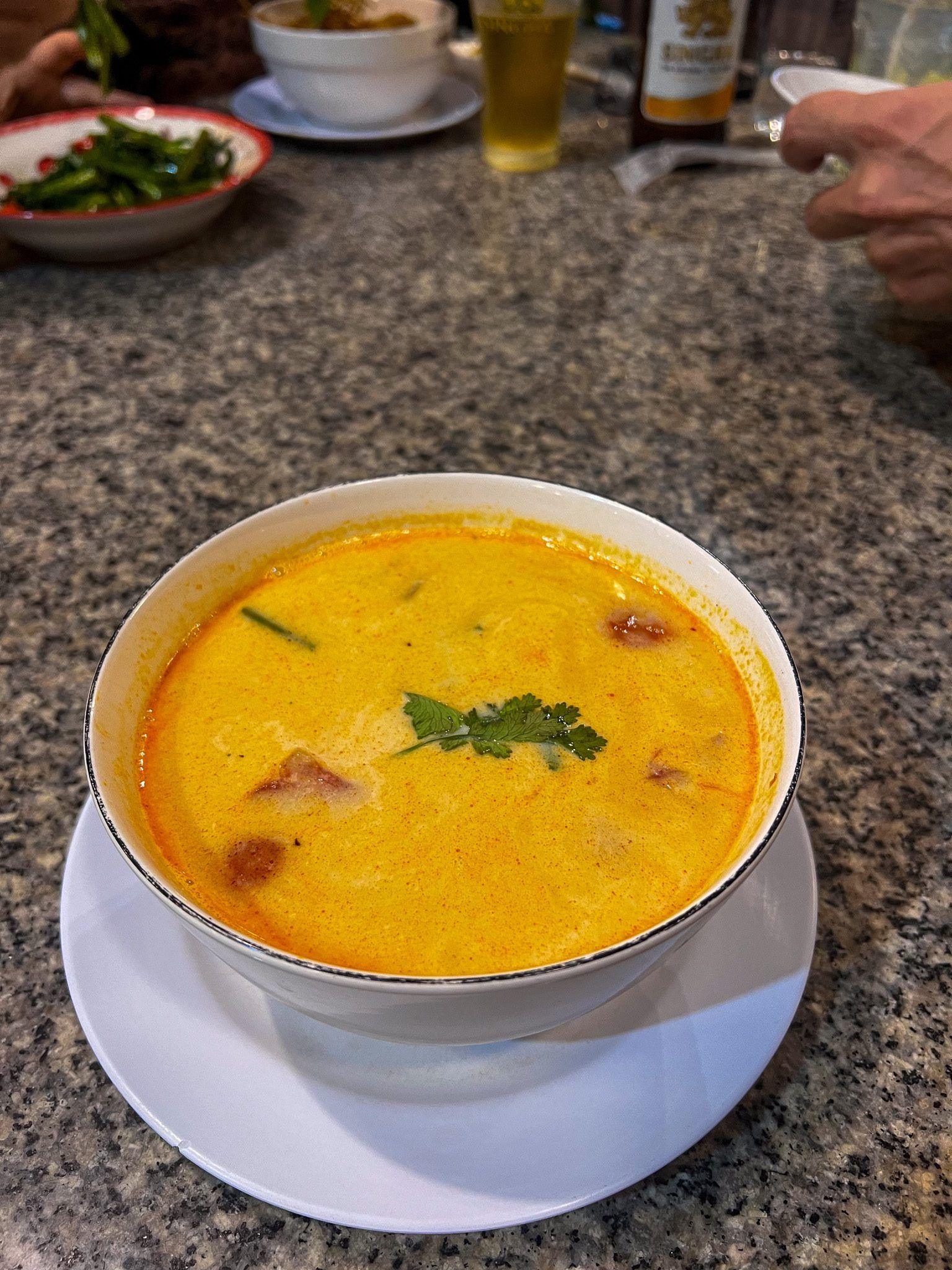 Tajska zupa kokosowa khao soi podana w białej misce