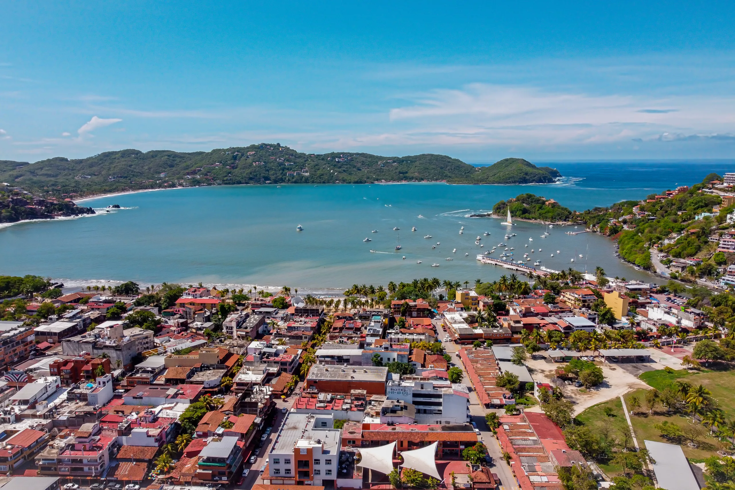 Panoramiczny widok z lotu ptaka na Zihuatanejo – nadmorskie miasteczko w Meksyku z kolorowymi zabudowaniami, palmami i zatoką pełną łodzi