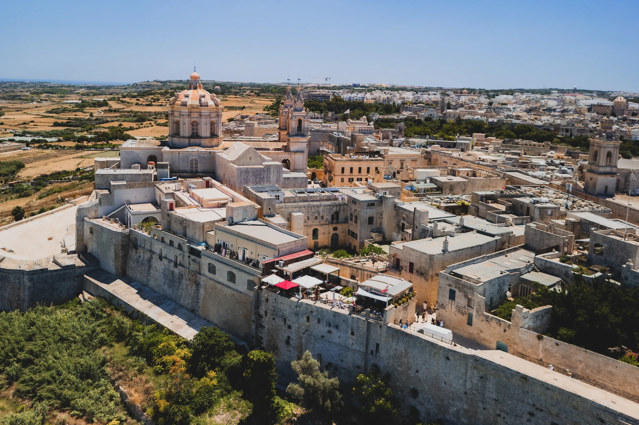 Panorama Mdiny na Malcie – ufortyfikowane miasto z widoczną kopułą katedry, wąskimi uliczkami i murami obronnymi otoczonymi polami