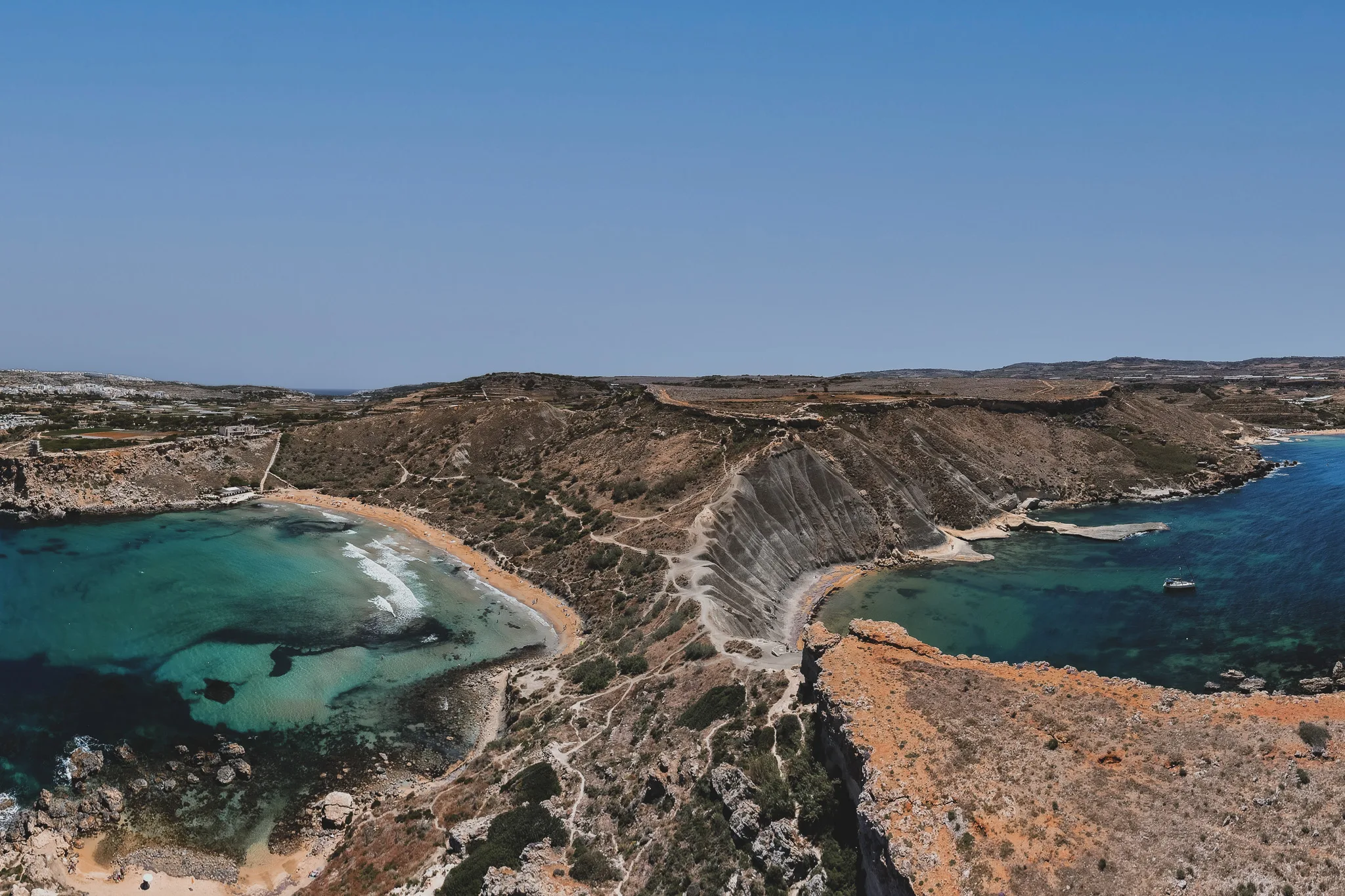 Zatoka Għajn Tuffieħa i plaża Riviera Bay – widok z lotu ptaka na złoty piasek, turkusowe morze i surowe zbocza Malty