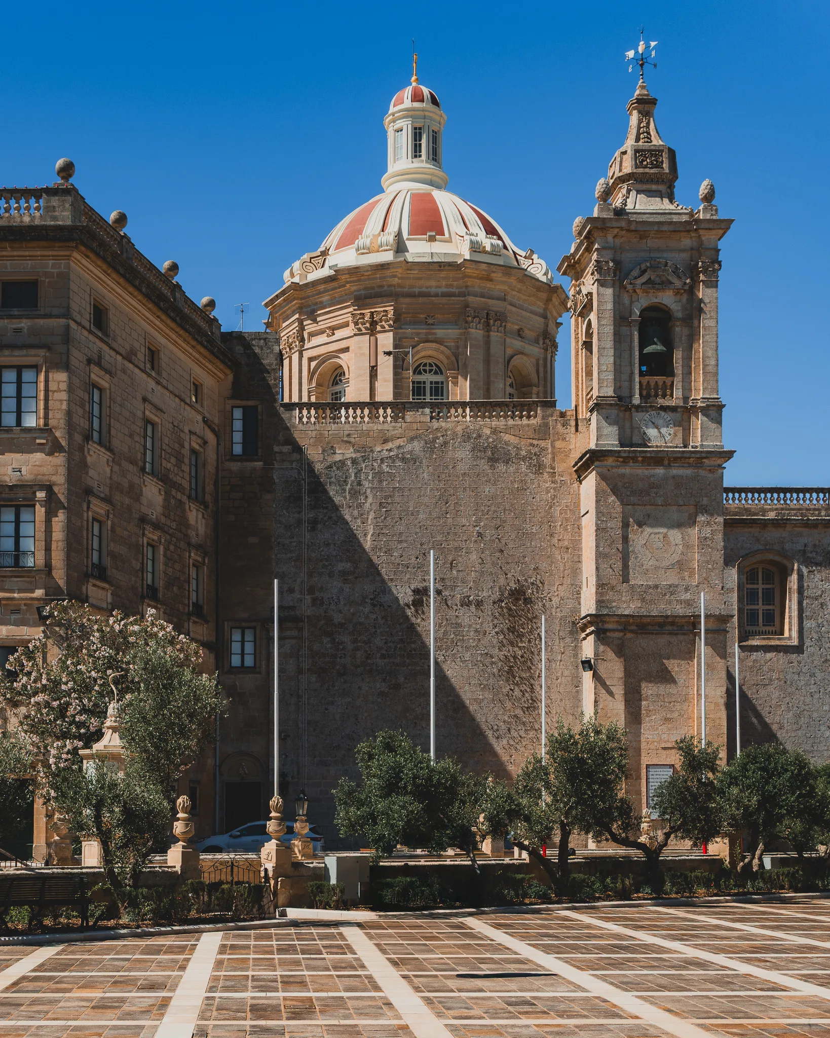 Barokowa kopuła kościoła św. Pawła w Rabacie na Malcie z czerwonym dachem i wieżą zegarową na tle błękitnego nieba
