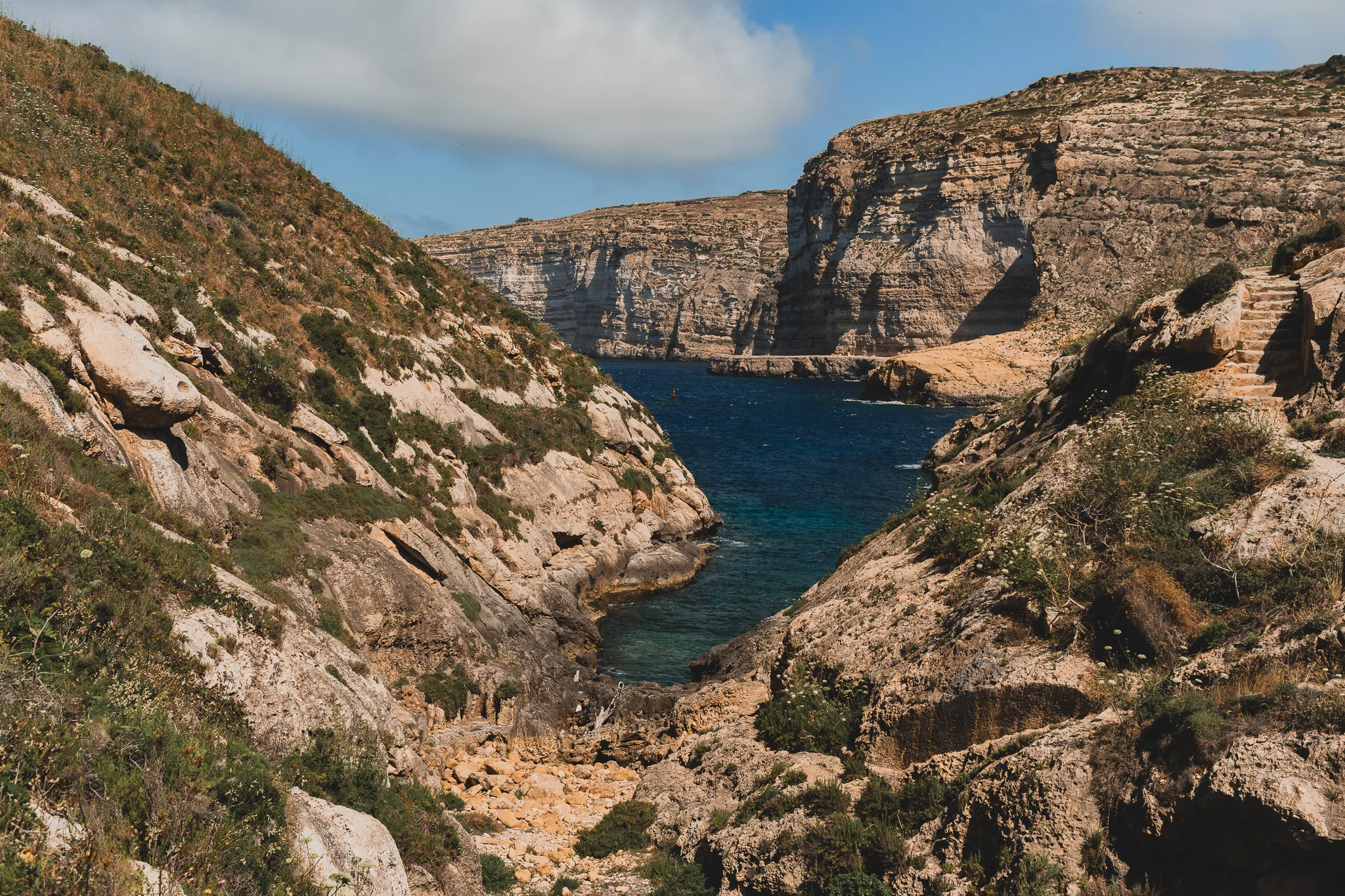 Wąwóz Wied il-Għasri na Gozo – malownicza zatoczka z turkusową wodą otoczona wapiennymi klifami i ścieżką skalną