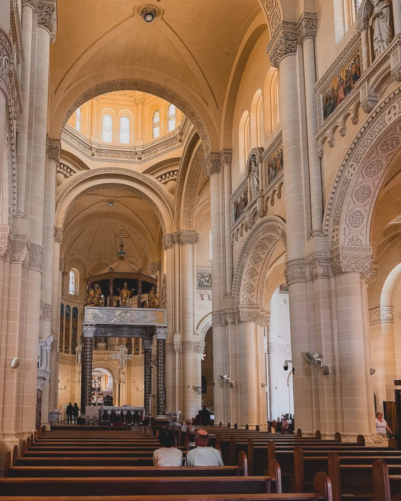 Nawa główna Bazyliki Ta’ Pinu z widokiem na ołtarz, zdobione kolumny i misterną architekturę wnętrza