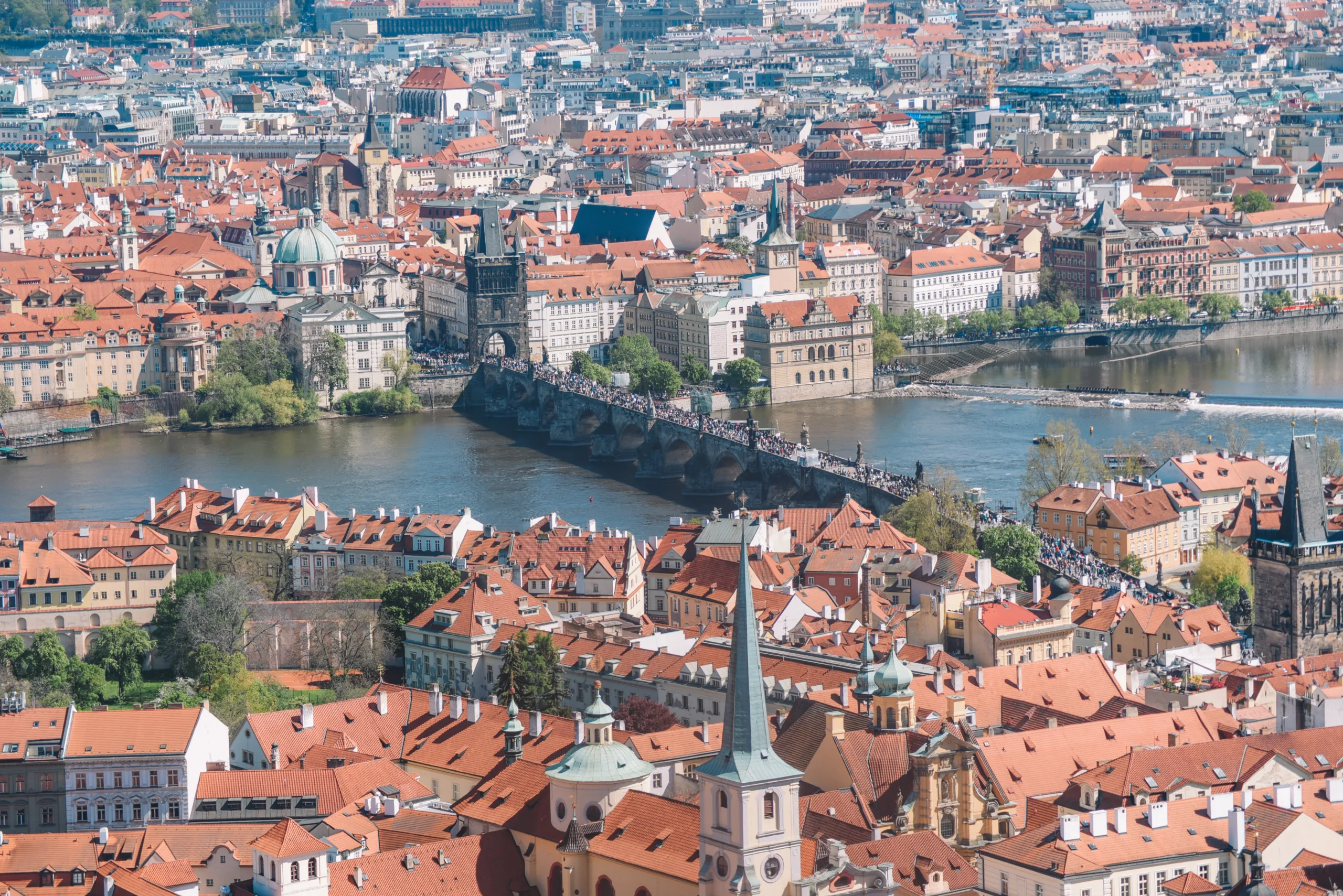 Panorama Pragi z Mostem Karola, czerwonymi dachami Starego Miasta i Wełtawą przecinającą miasto