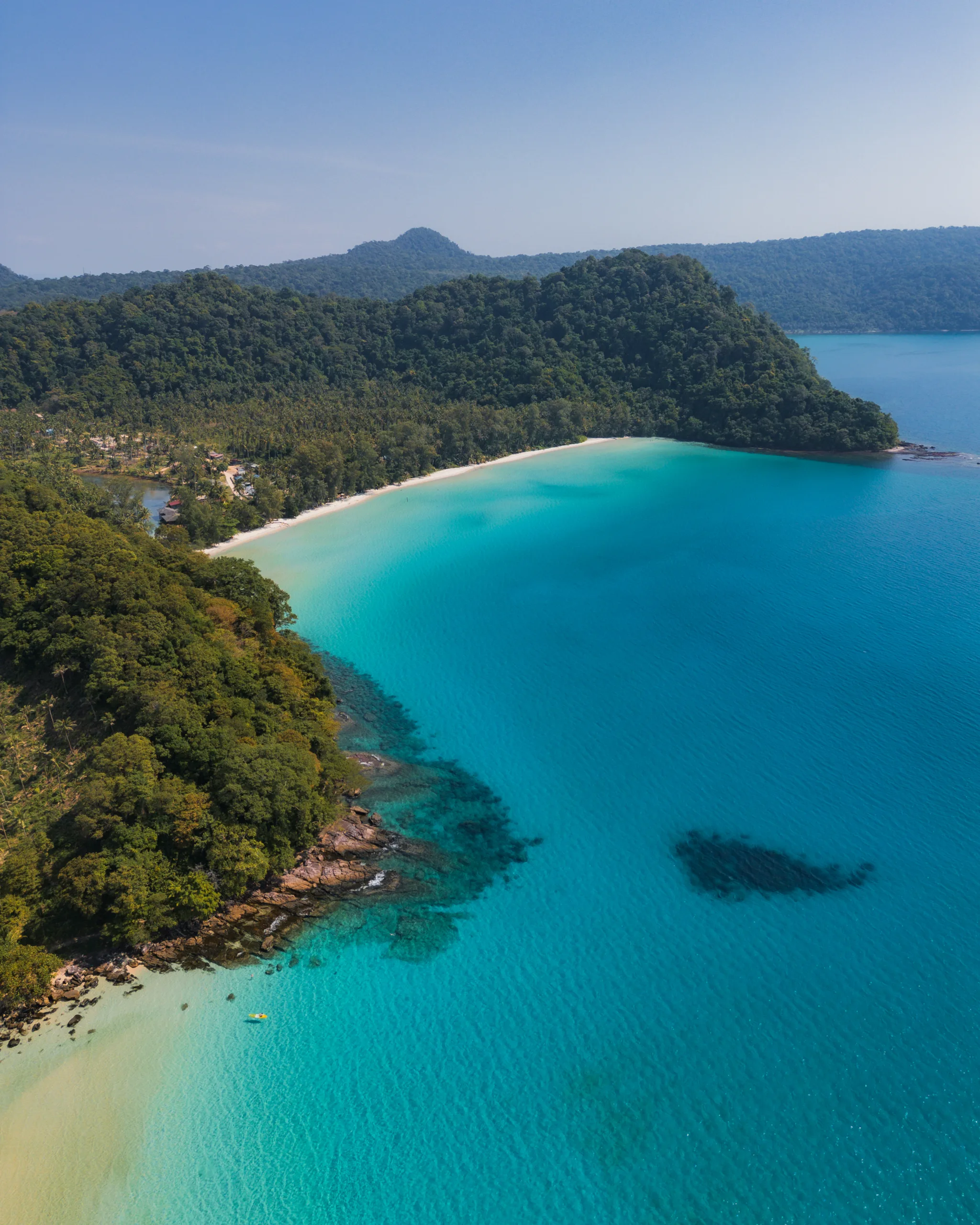 Turkusowa zatoka otoczona zielonym wzgórzem i białą plażą – ukryty raj w Tajlandii