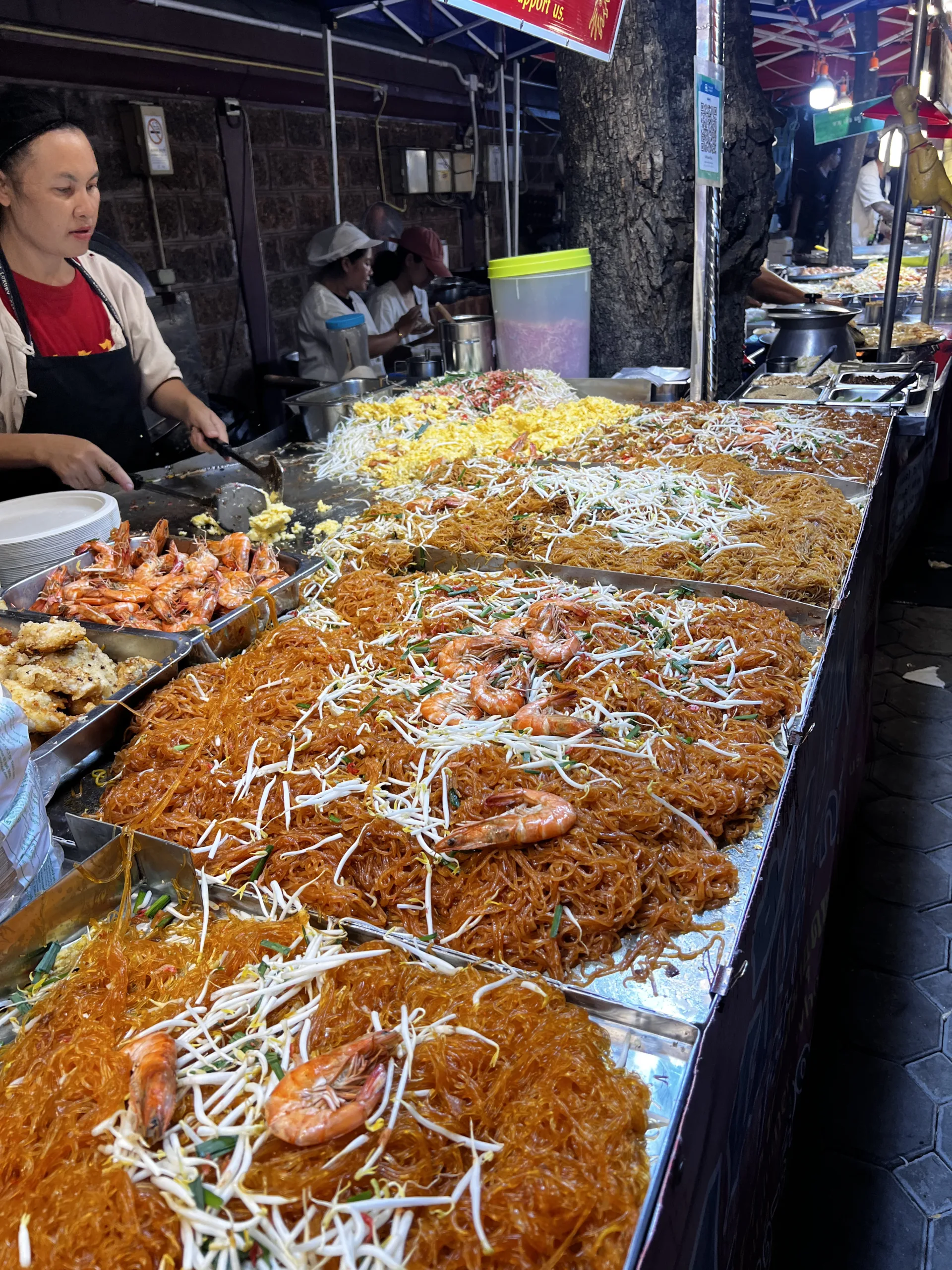 Tajska uliczna restauracja z kolorowymi stolikami i klimatem lokalnego street foodu