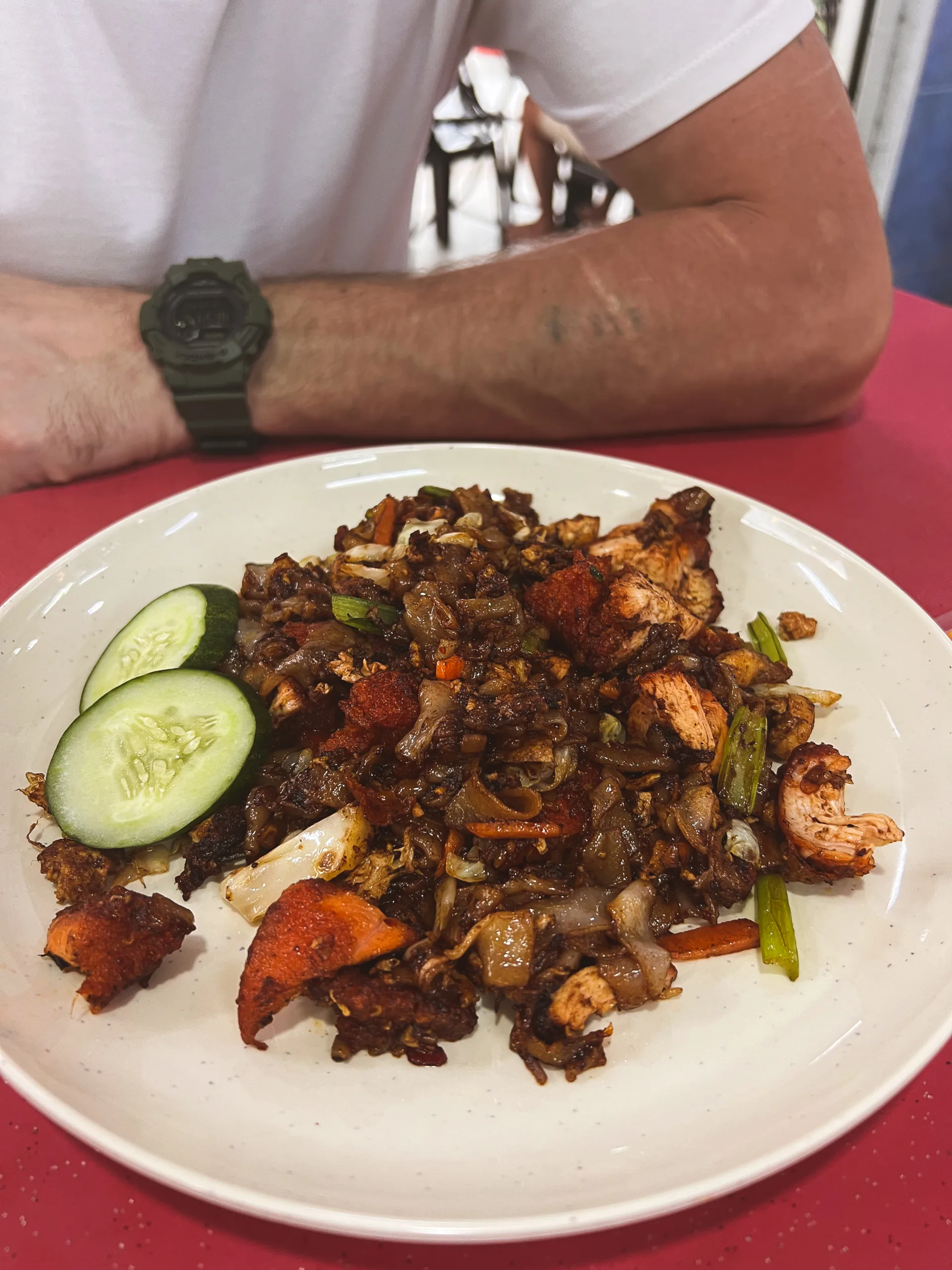 Char Kway Teow – smażony szeroki makaron ryżowy z kurczakiem, warzywami, jajkiem i przyprawami, podany z plastrami świeżego ogórka