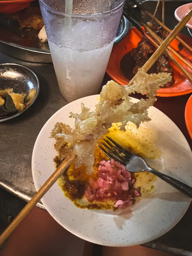 Meduza podana na patyku w stylu malezyjskiego Lok Lok, serwowana z sosem curry i marynowaną cebulą