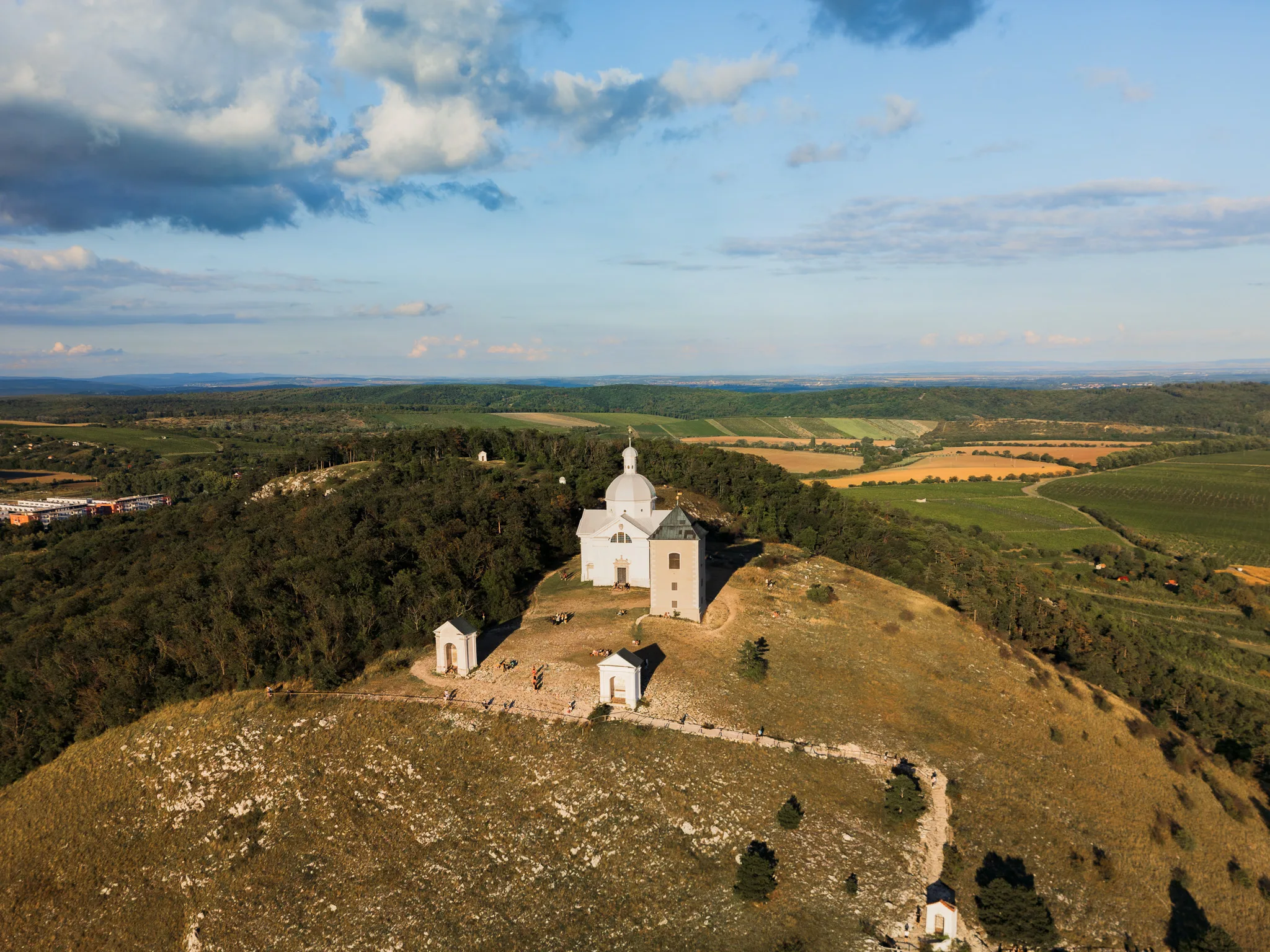 Kościół św. Sebastiana na Świętej Górce w Mikulovie z lotu ptaka, otoczony winnicami i polami Moraw Południowych.