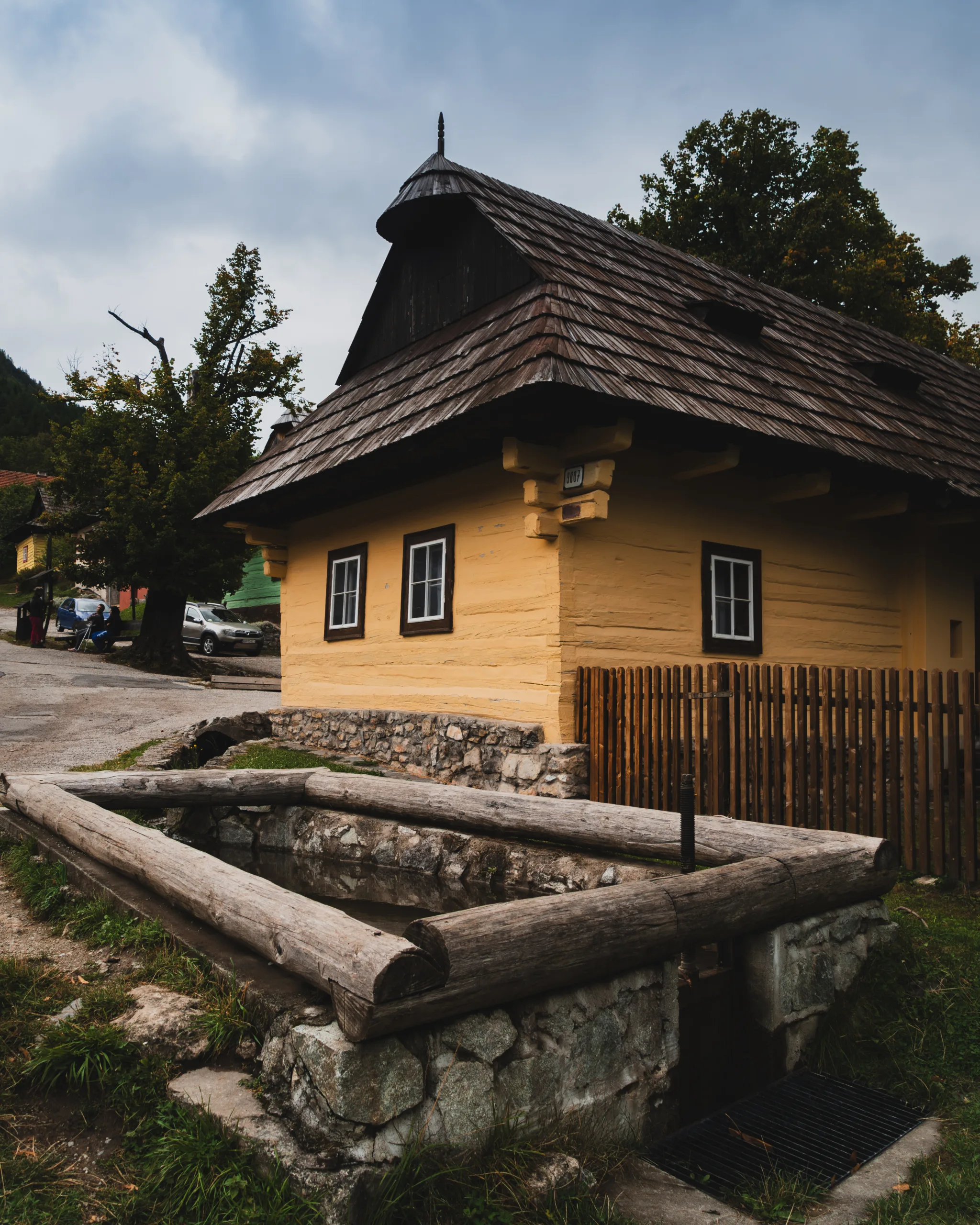 Drewniana chata we wsi Vlkolínec na Słowacji, wpisanej na listę UNESCO, z tradycyjną studnią obok domu.