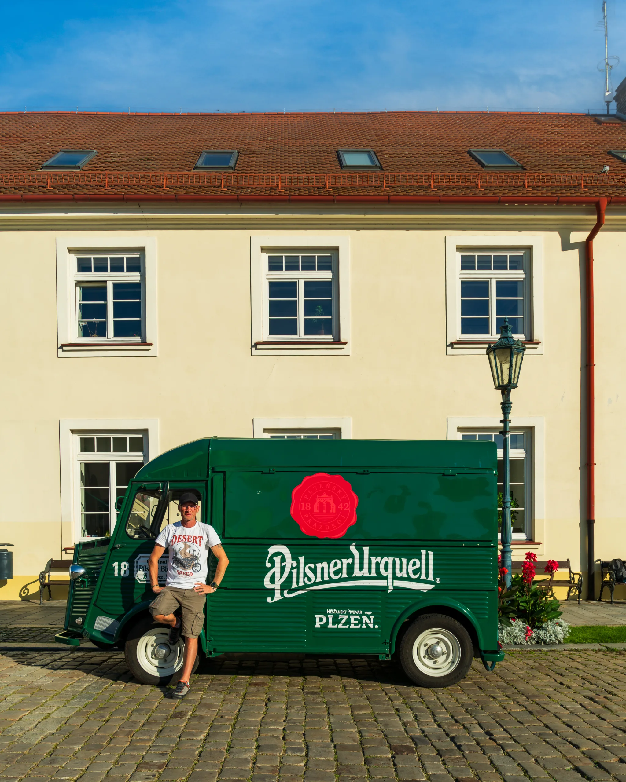Zielony samochód dostawczy Pilsner Urquell w Pilźnie, z osobą pozującą obok.