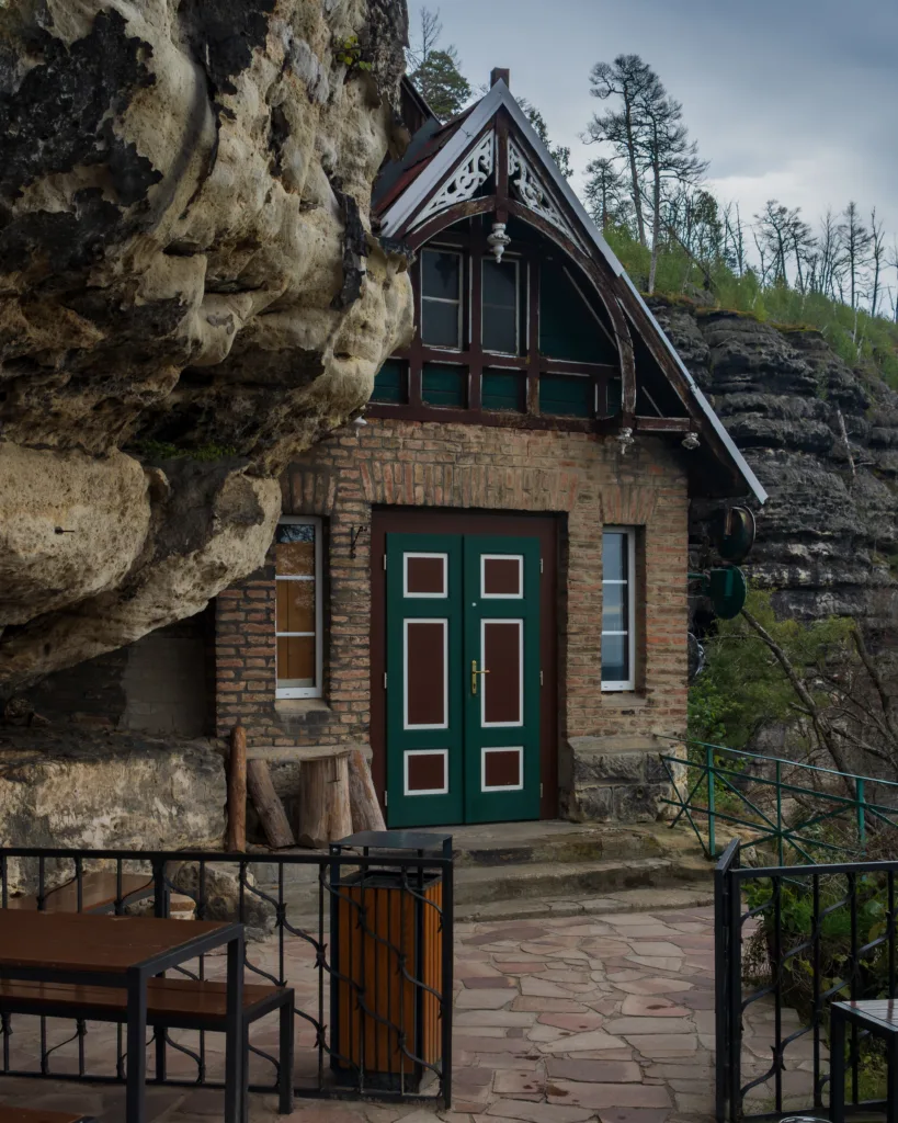 Wejście do kamiennego domku przy schronisku Sokolí hnízdo obok Pravčickiej Bramy w Czeskiej Szwajcarii.