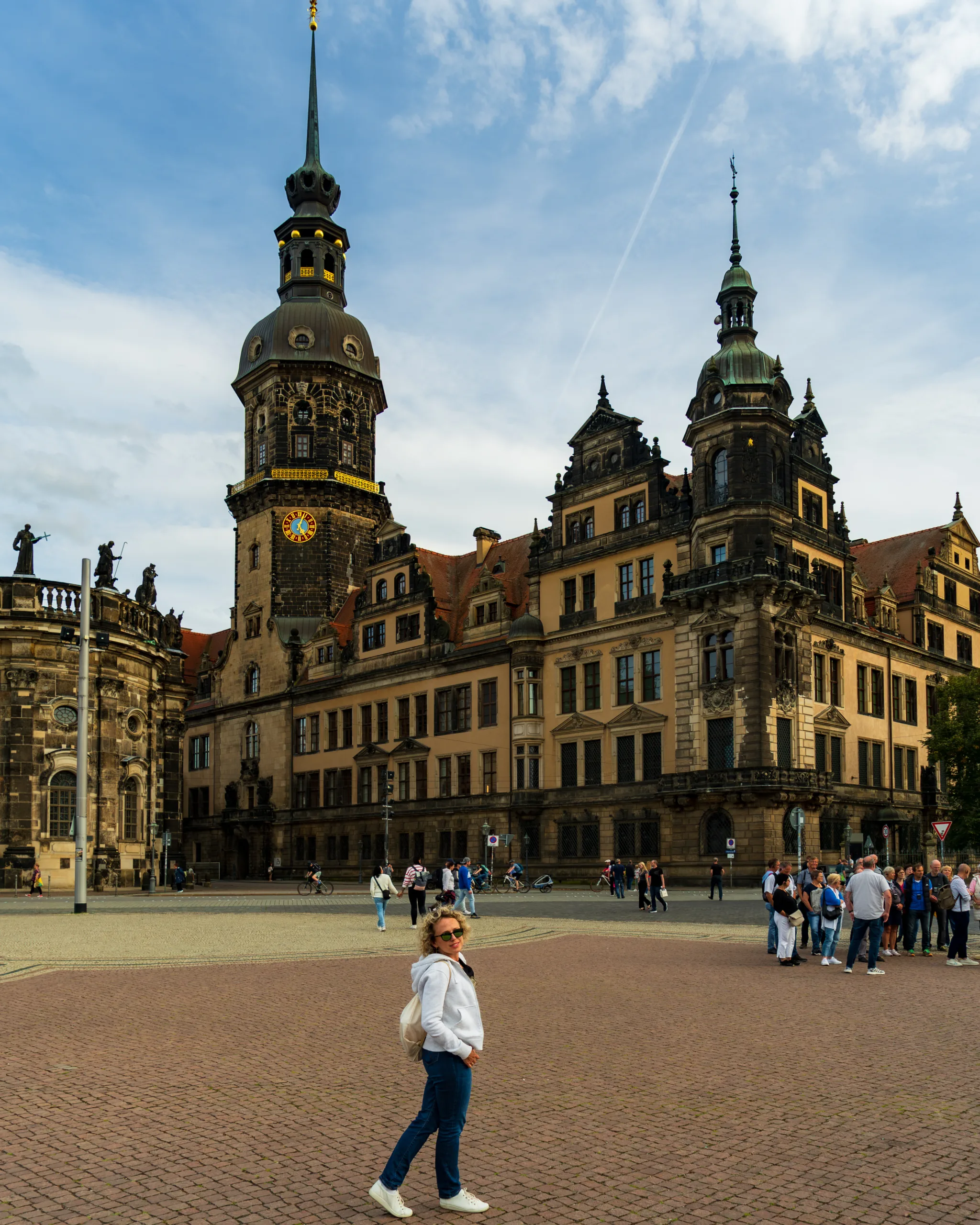 Turystka spacerująca po placu Schlossplatz w Dreźnie, z widokiem na monumentalny Zamek Królewski i wieżę Hausmannsturm.