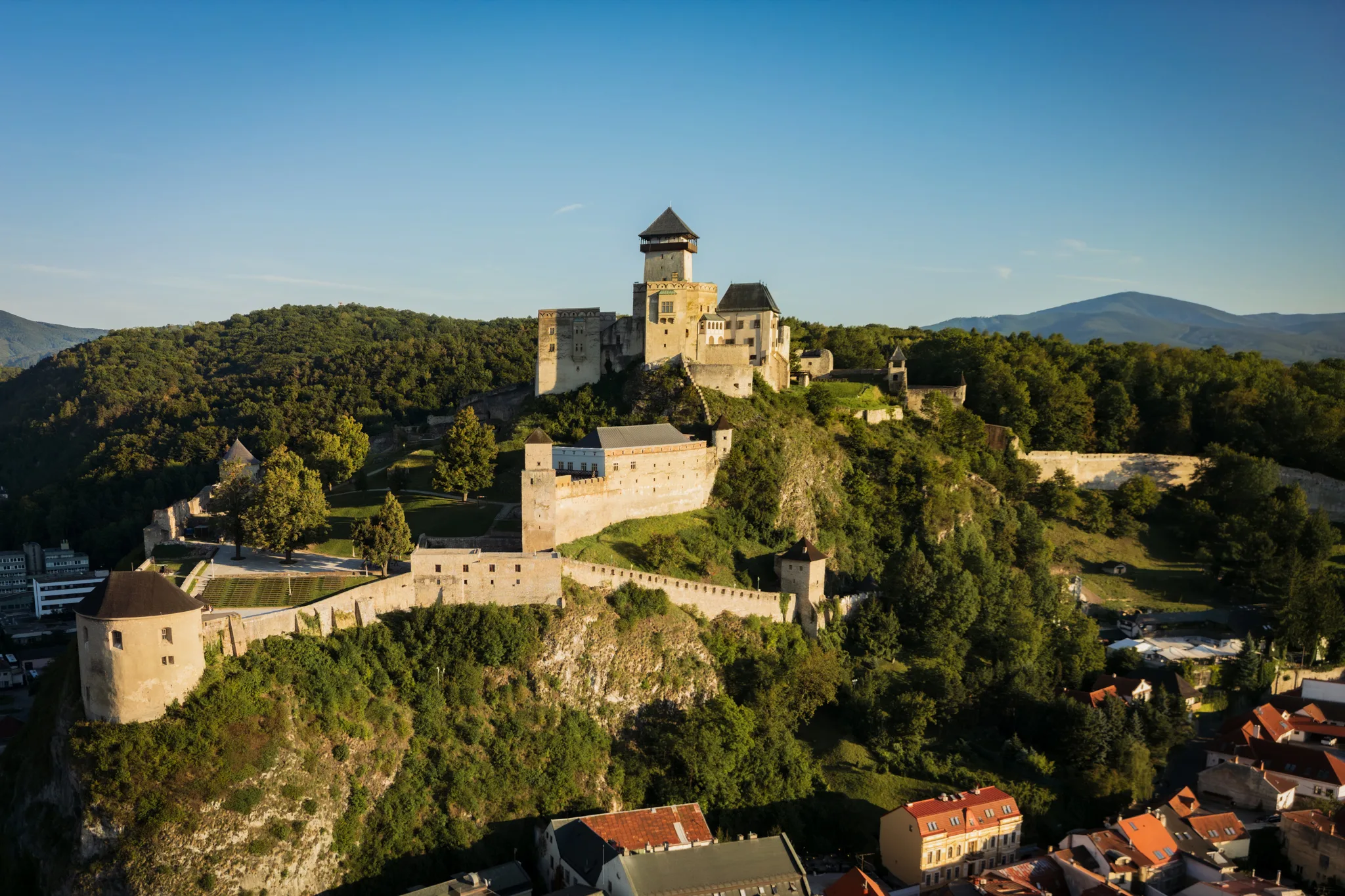 Zamek w Trenczynie na Słowacji – widok lotniczy na twierdzę położoną na wzgórzu z murami obronnymi i basztami.
