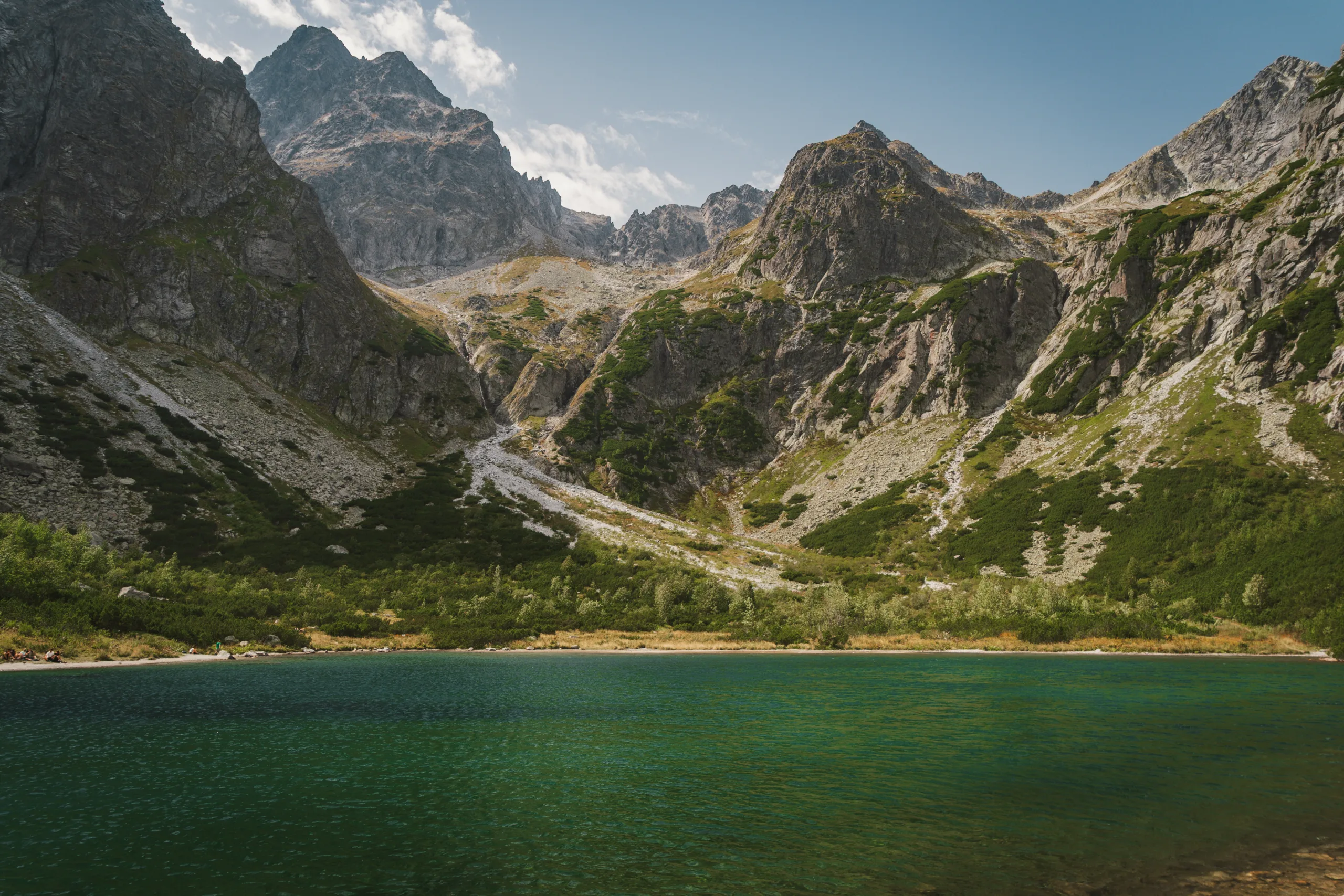 Górskie jezioro o turkusowej wodzie w Tatrach Wysokich, otoczone skalistymi szczytami i zielonymi zboczami - Zielony Staw Kieżmarski
