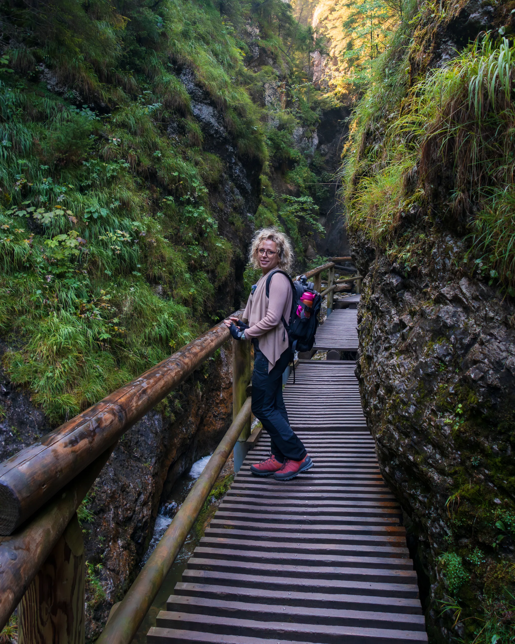 Turystka na drewnianym pomoście w wąwozie podczas trekkingu w Małej Fatrze.