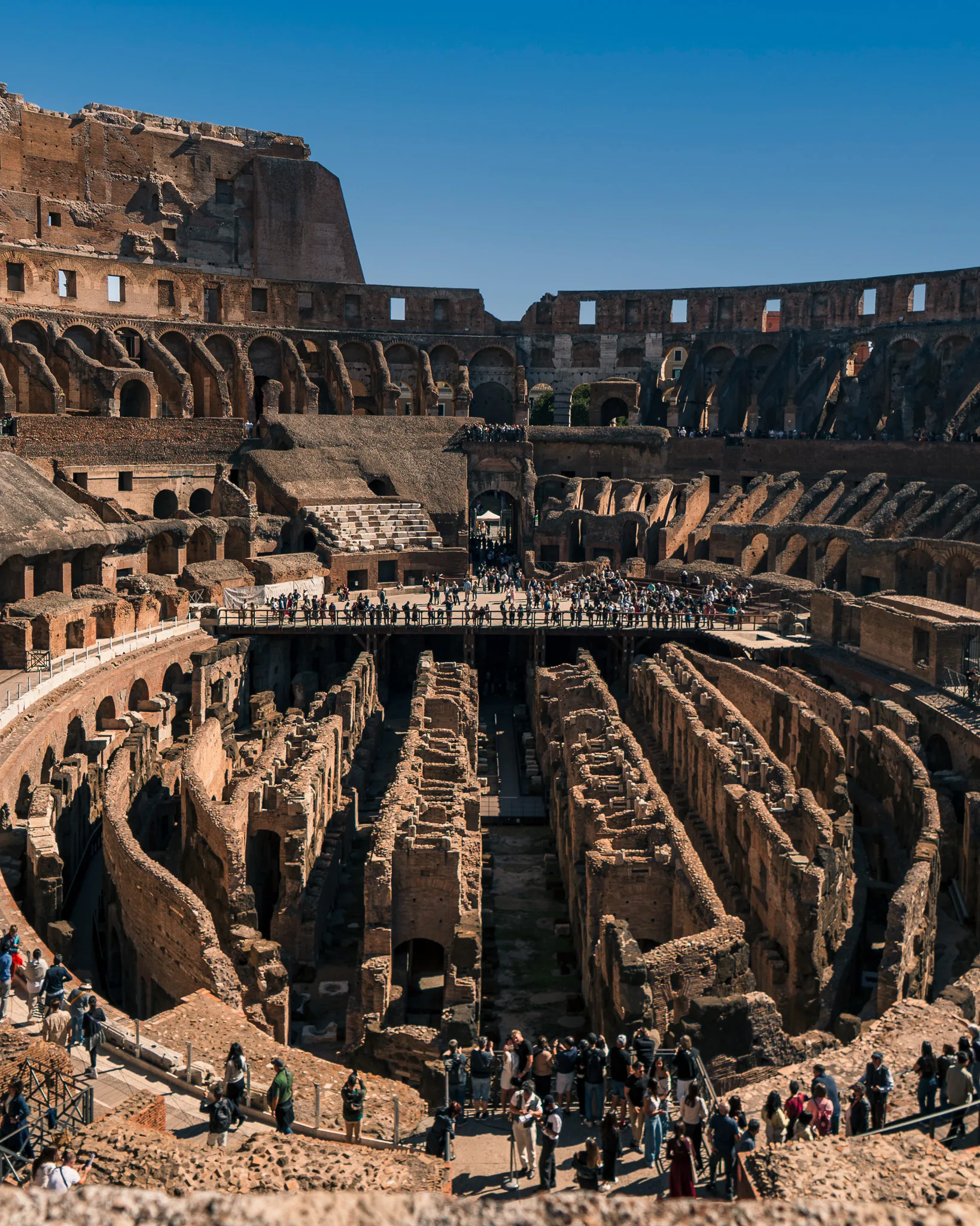 Wnętrze Koloseum w Rzymie z widokiem na podziemia i turystów zwiedzających starożytny amfiteatr
