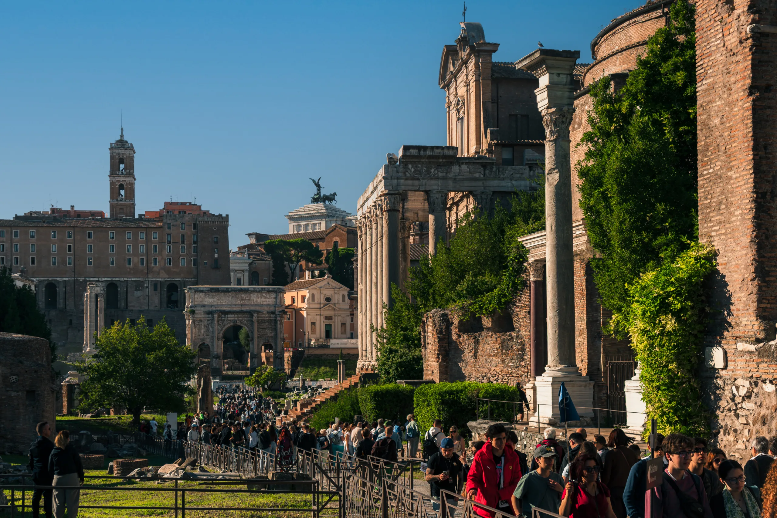 Forum Romanum w Rzymie o poranku, z kolumnami świątyń i tłumem zwiedzających na tle Kapitolu