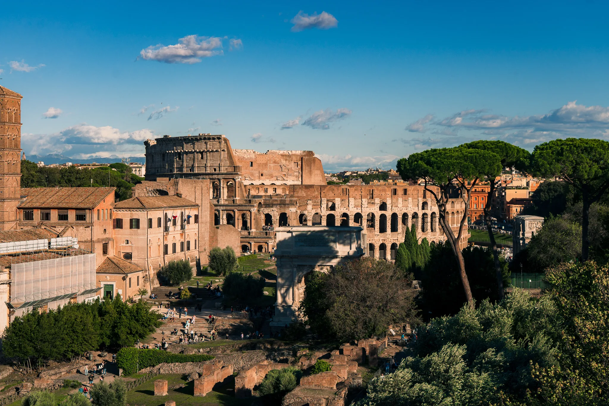 Panorama Koloseum w Rzymie widziana z Palatynu, otoczona historycznymi budynkami i zielenią