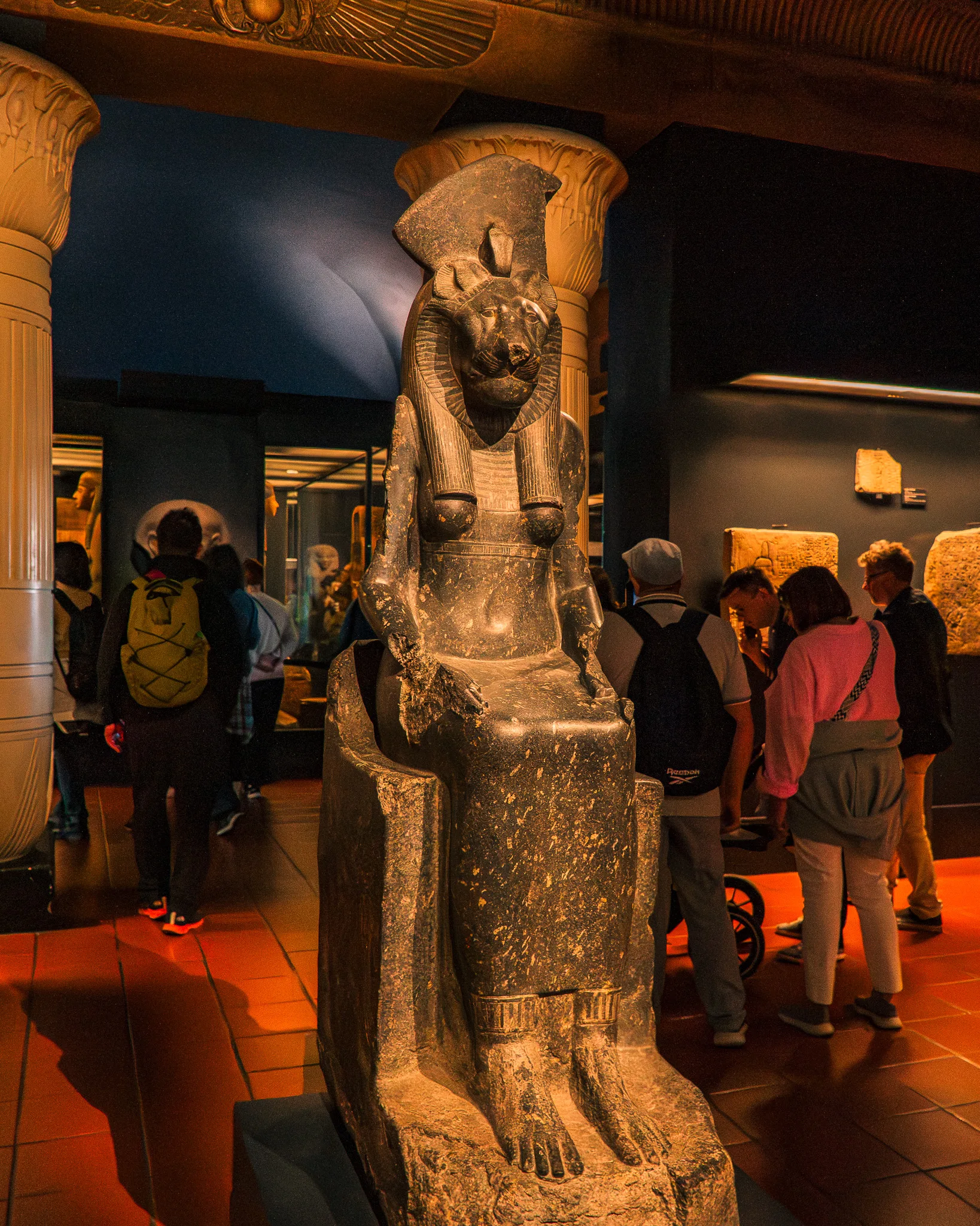 Egipska rzeźba bogini Sekhmet w Muzeach Watykańskich, otoczona przez zwiedzających w sali egipskiej