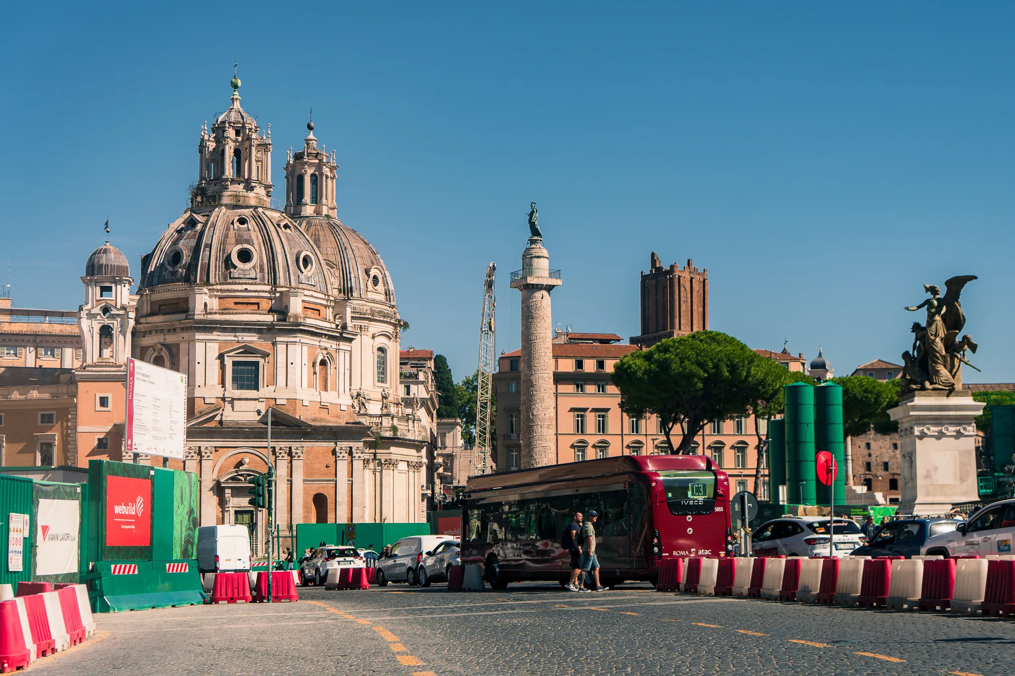 Kościół Najświętszego Imienia Maryi i kolumna Trajana na Piazza Venezia w Rzymie w słoneczny dzień.