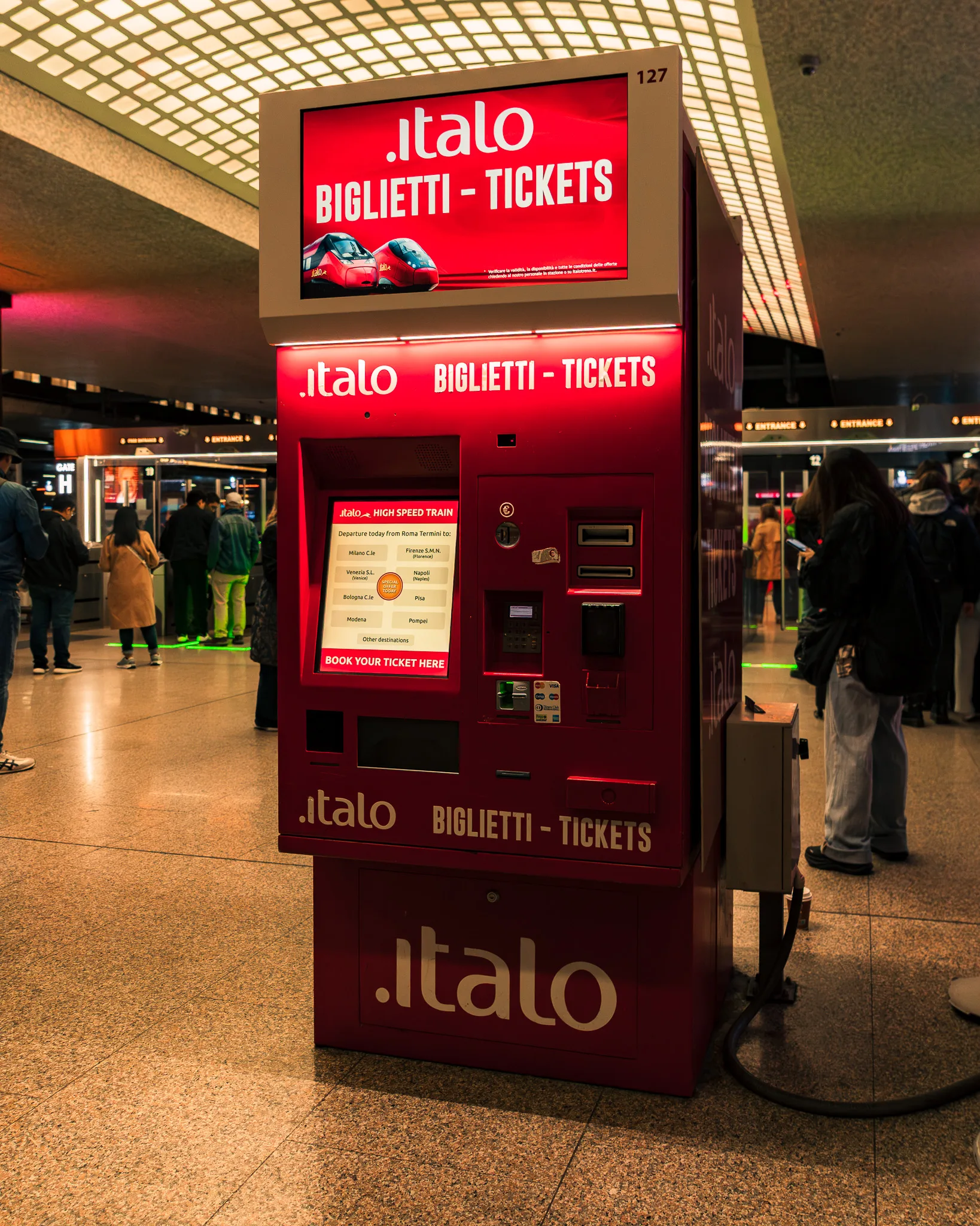 Czerwony automat biletowy Italo na dworcu we Włoszech, służący do zakupu biletów na szybkie pociągi.