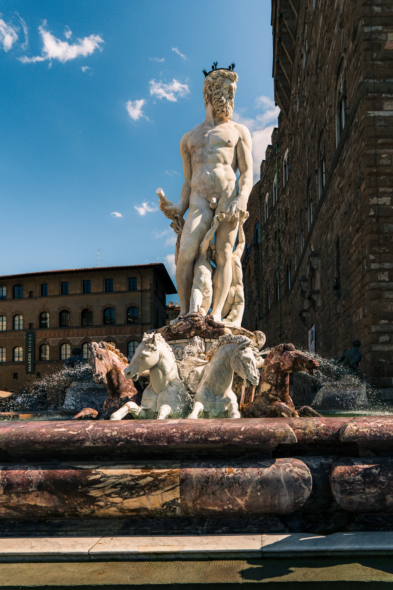 Fontanna Neptuna na Piazza della Signoria we Florencji z monumentalną rzeźbą Neptuna i końmi morskimi w słońcu - Florencja