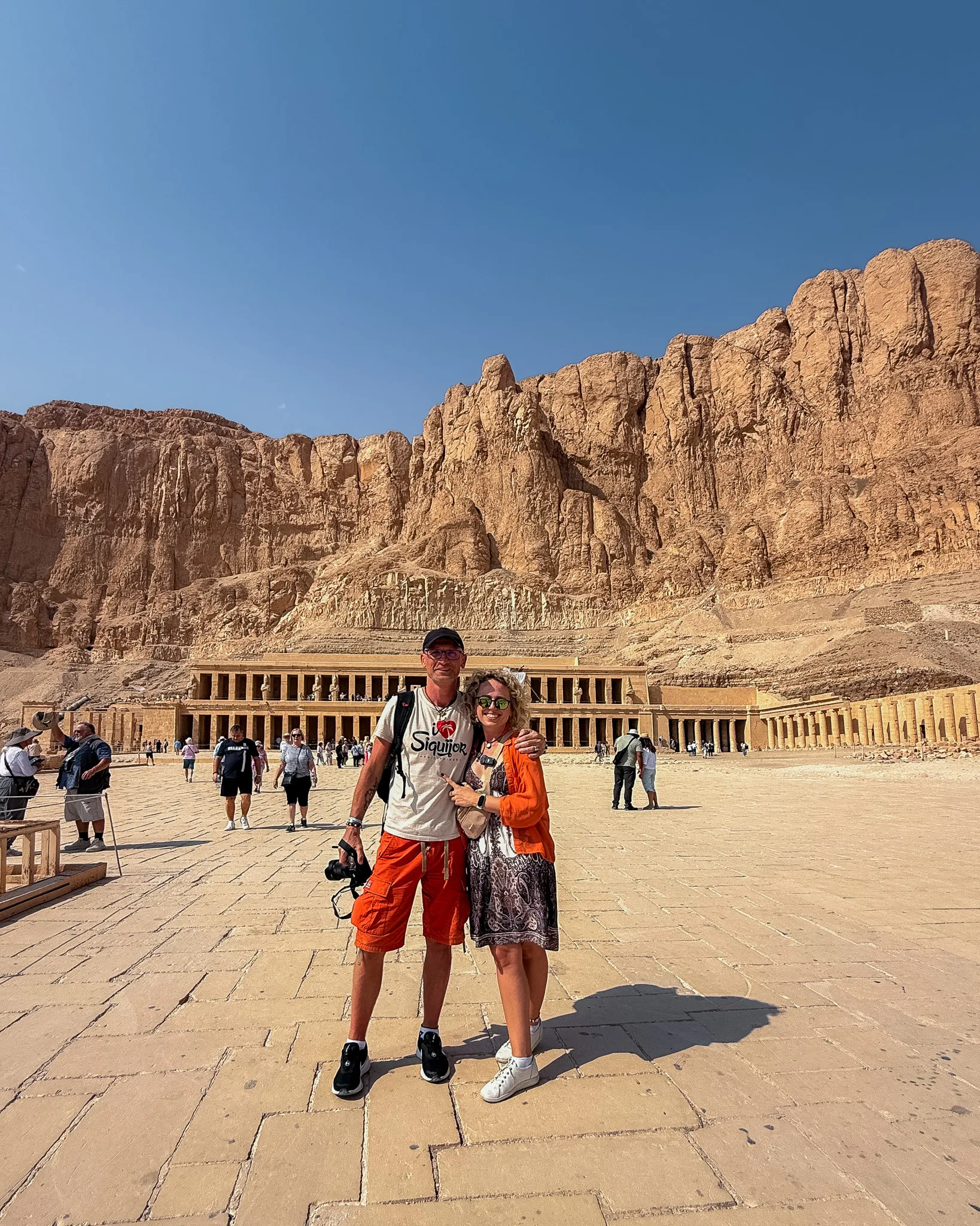 Agata i Paweł na tle świątyni Hatszepsut w Luksorze; monumentalne klify i tarasy świątyni w pełnym słońcu.
