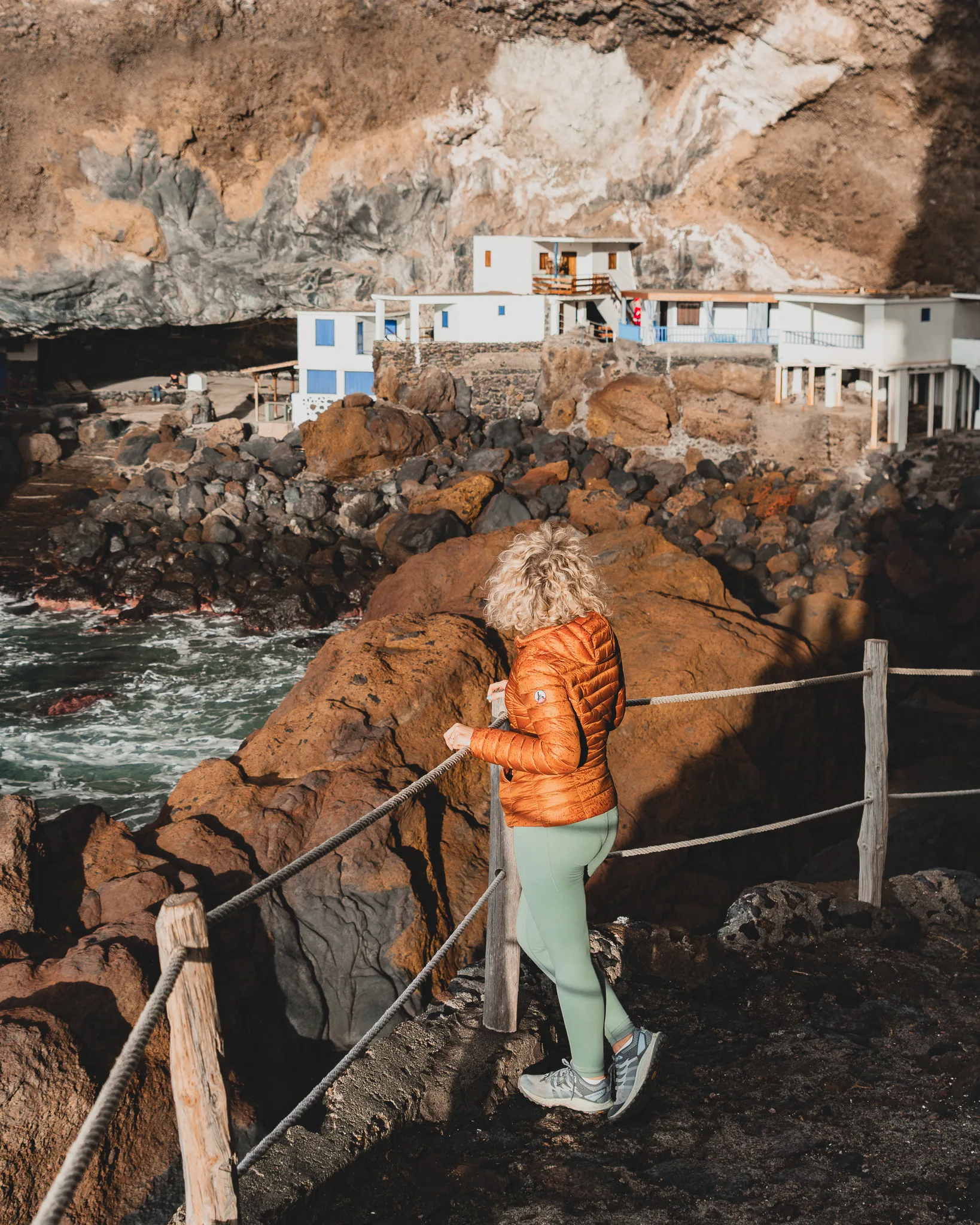 Skaliste wybrzeże La Palmy z domkami wbudowanymi w klif, widok z perspektywy spacerowej.