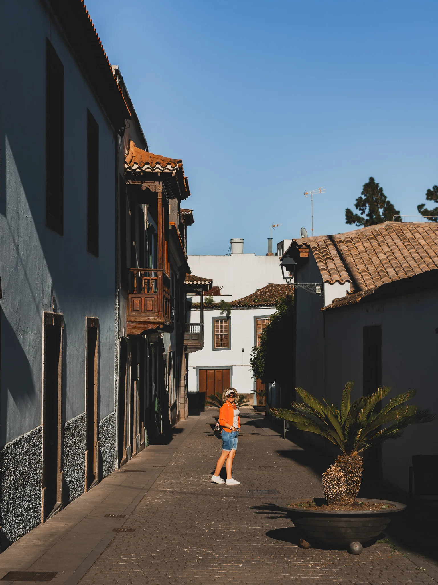 Gran Canaria: Teror – wąska uliczka ze starymi domami i drewnianymi balkonami, kobieta na środku kadru