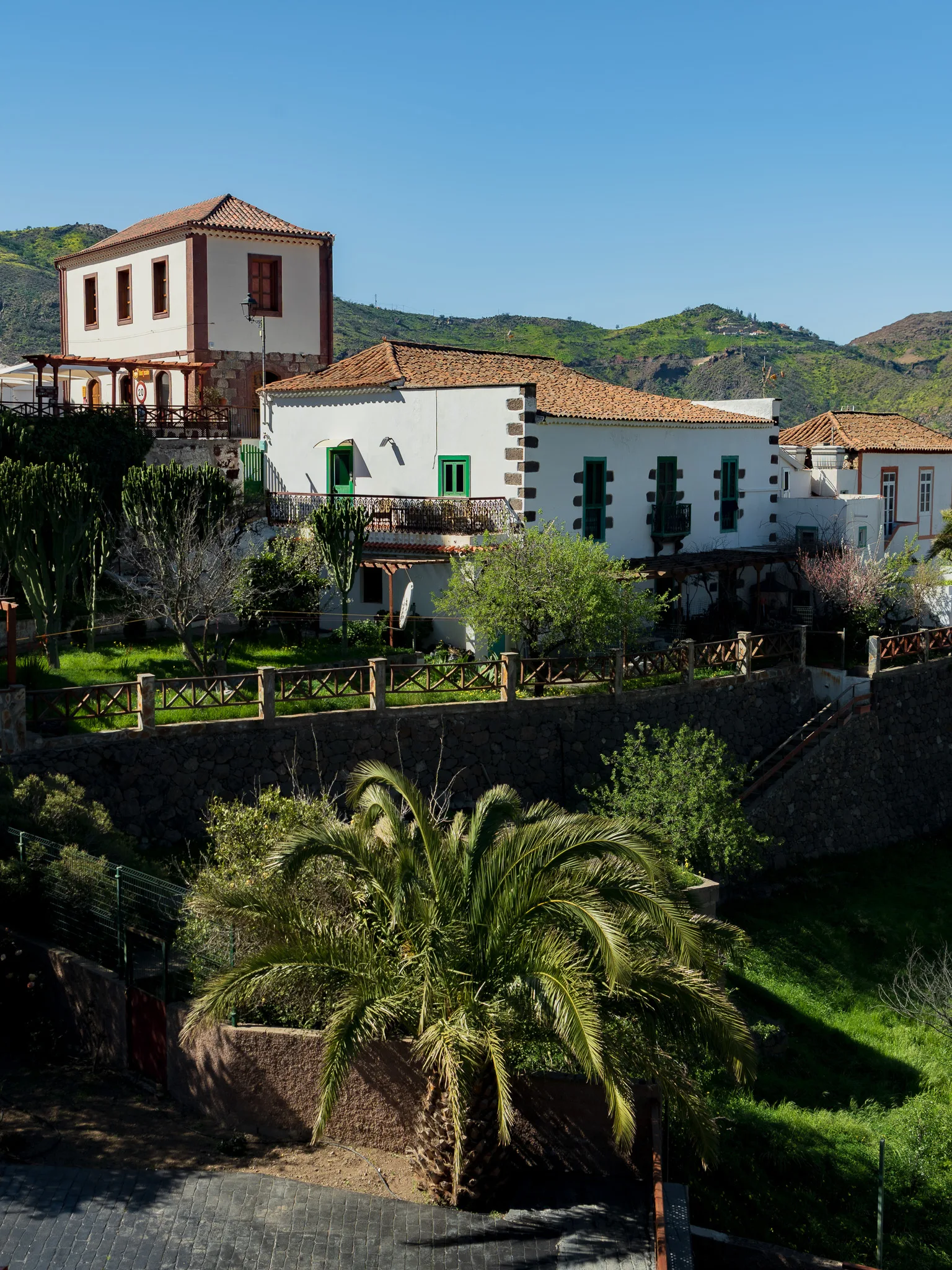 Gran Canaria: Tejeda – białe domy z zielonymi okiennicami i palmą na tle górskiej doliny