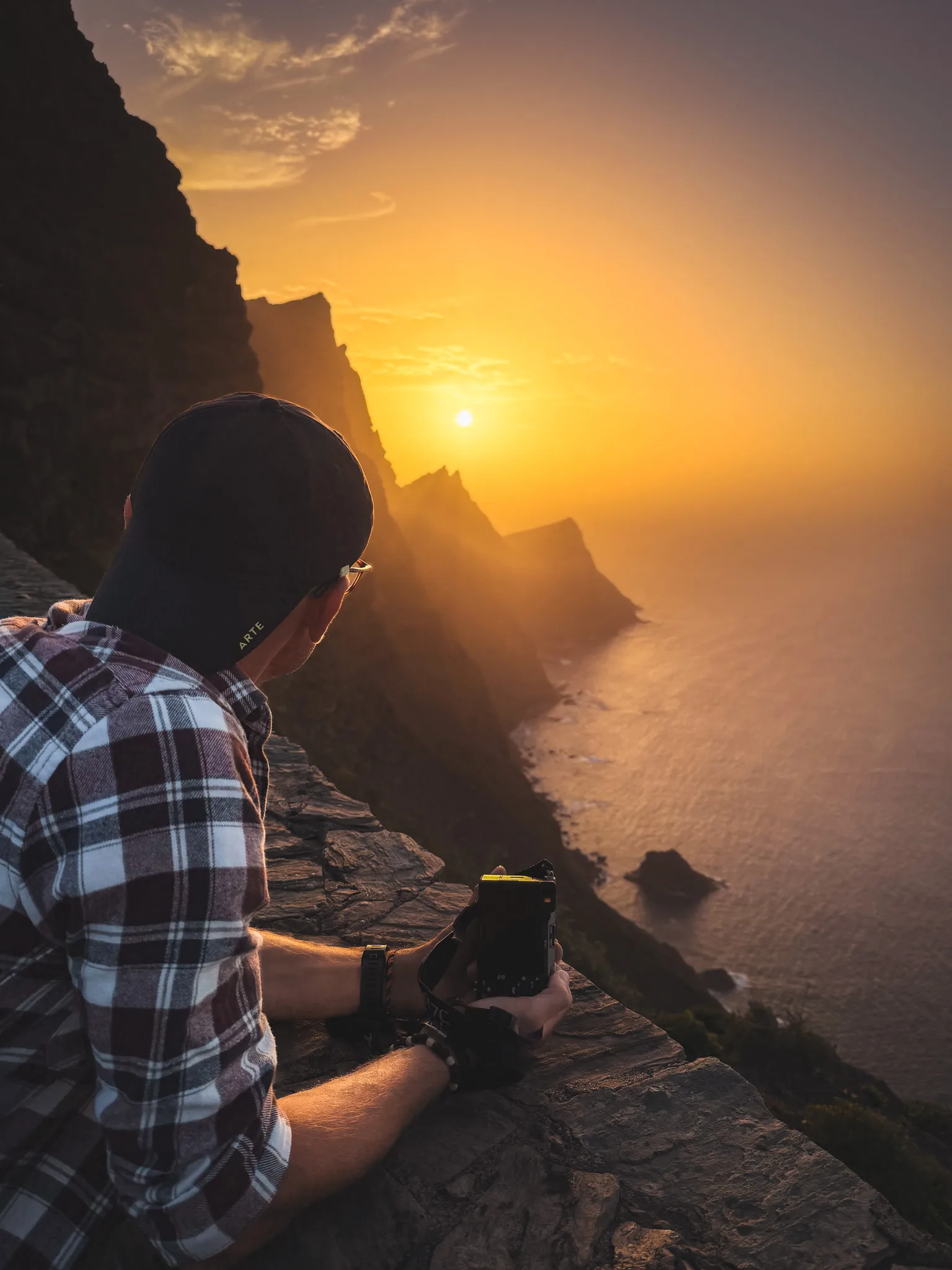 Gran Canaria: mężczyzna z aparatem na klifie, złota godzina i zachód słońca nad oceanem