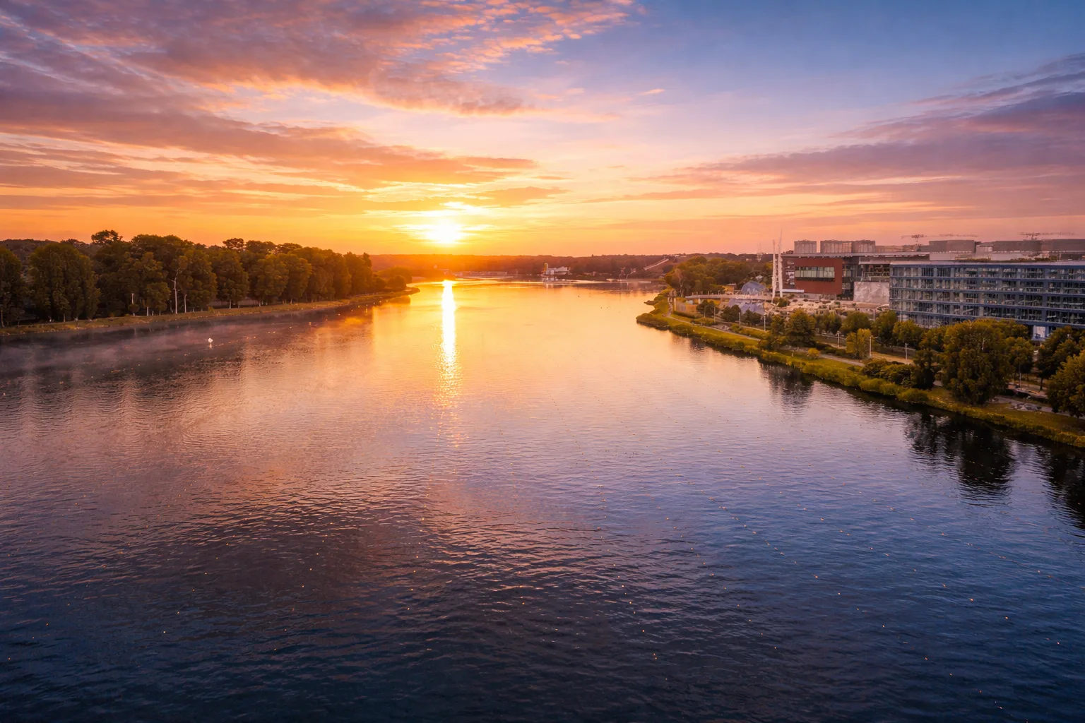 Jezioro Maltańskie w Poznaniu z trasą spacerową, zielenią i nowoczesną zabudową w tle.