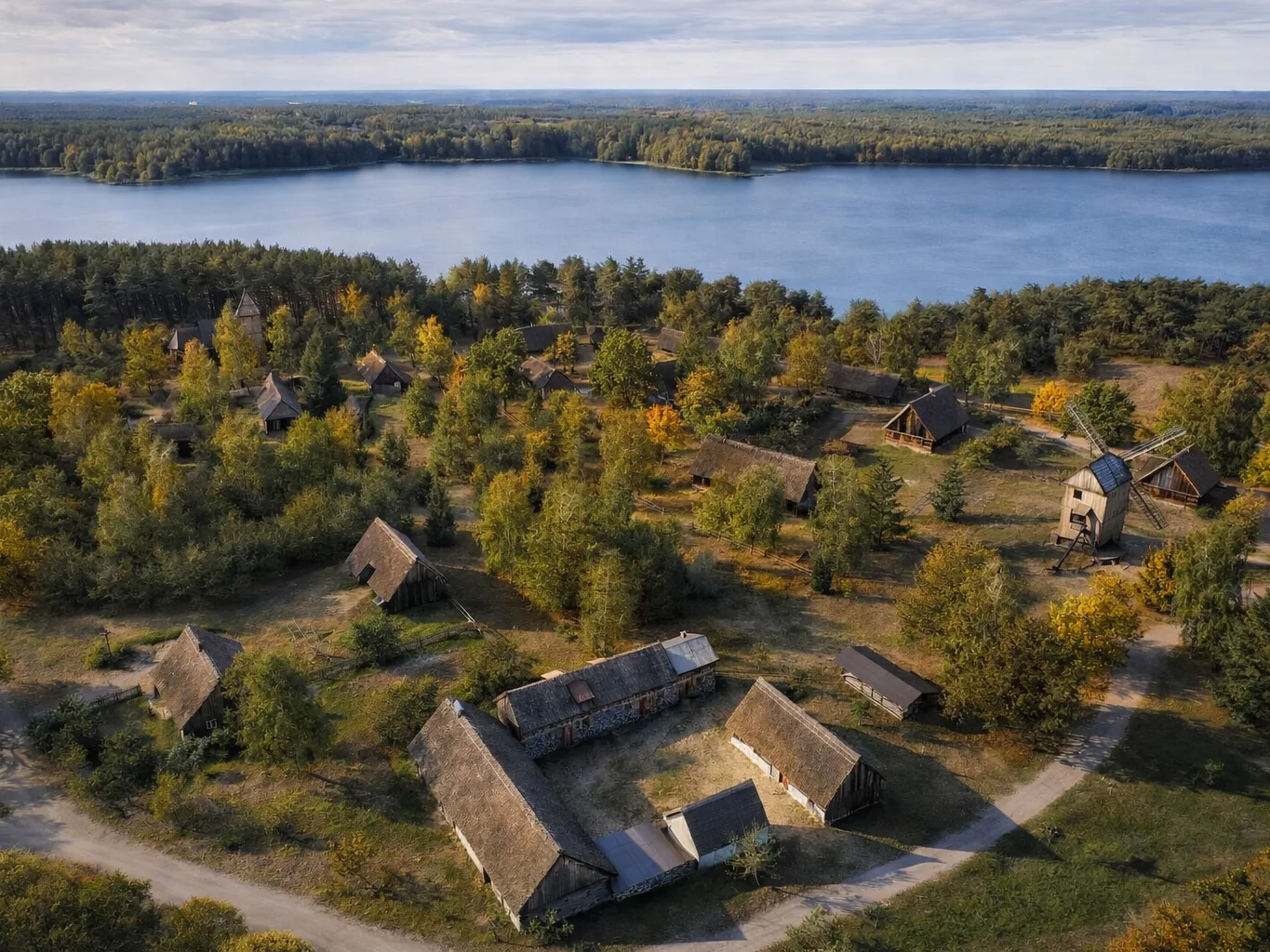 Muzeum – Kaszubski Park Etnograficzny we Wdzydzach z lotu ptaka – drewniane chaty, wiatrak i zabudowa skansenu nad jeziorem Wdzydze