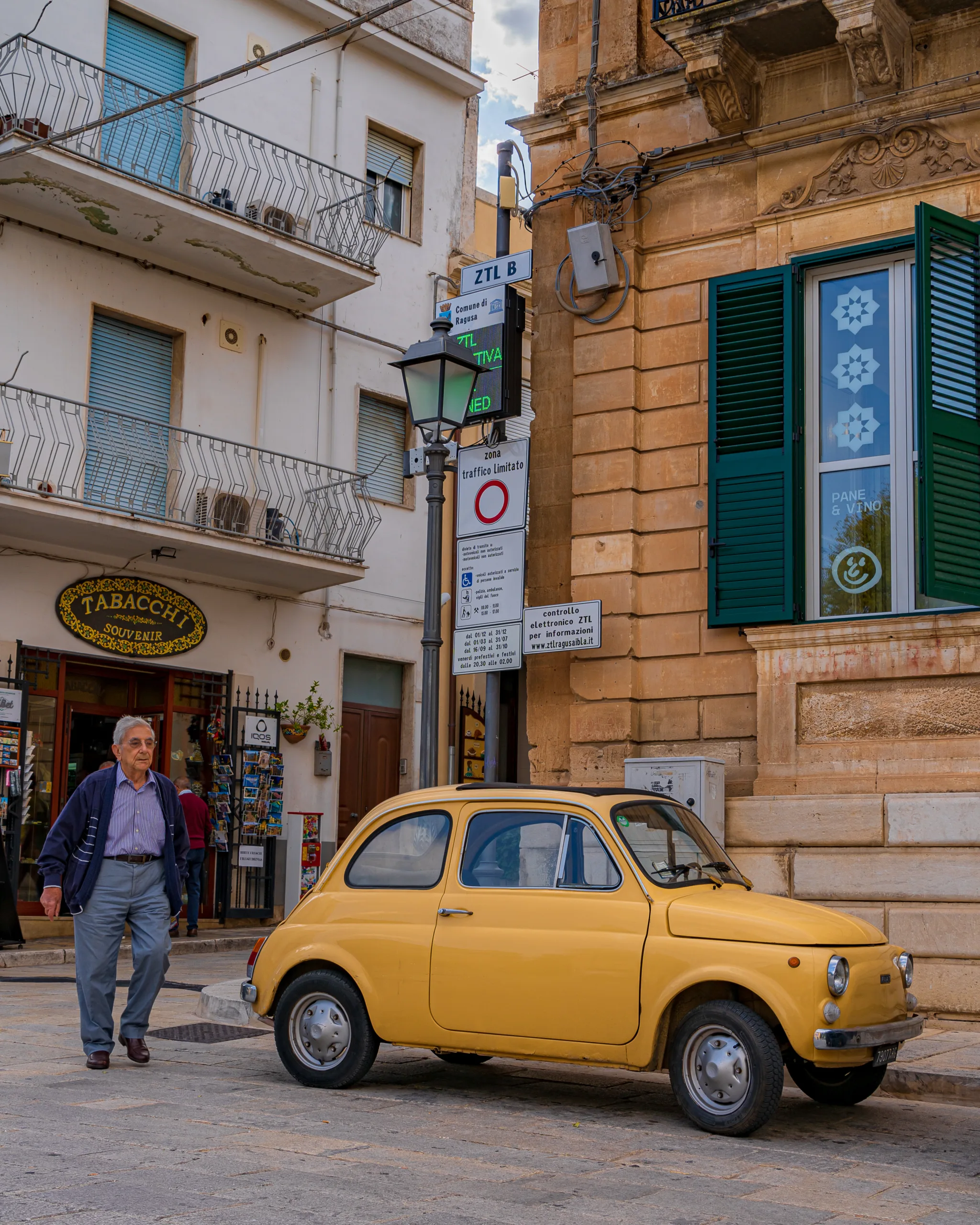 Żółty Fiat 500 zaparkowany przy zabytkowej ulicy w Ragusa Ibla na Sycylii